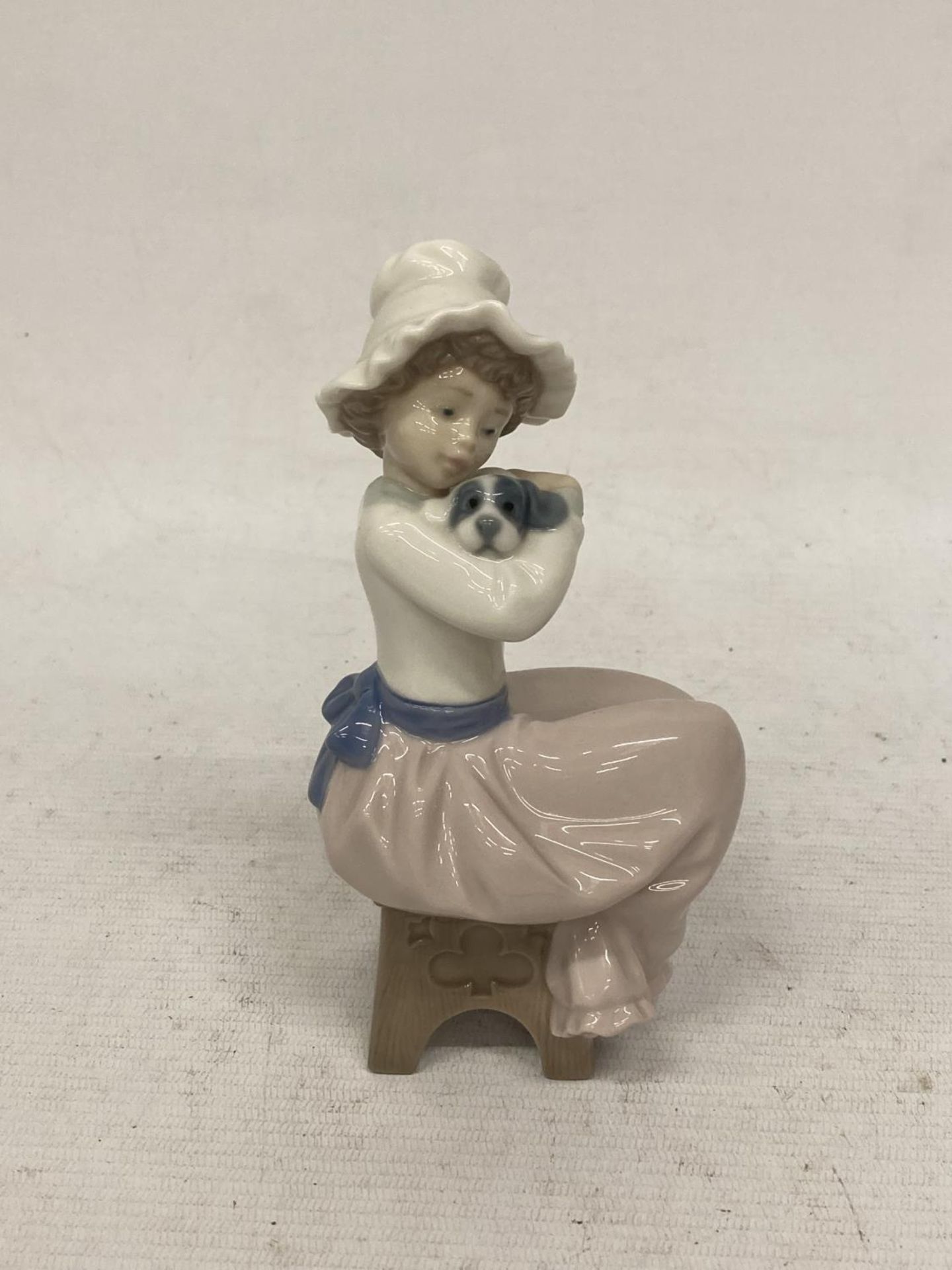 A NAO FIGURINE OF A GIRL HUGGING HER DOG