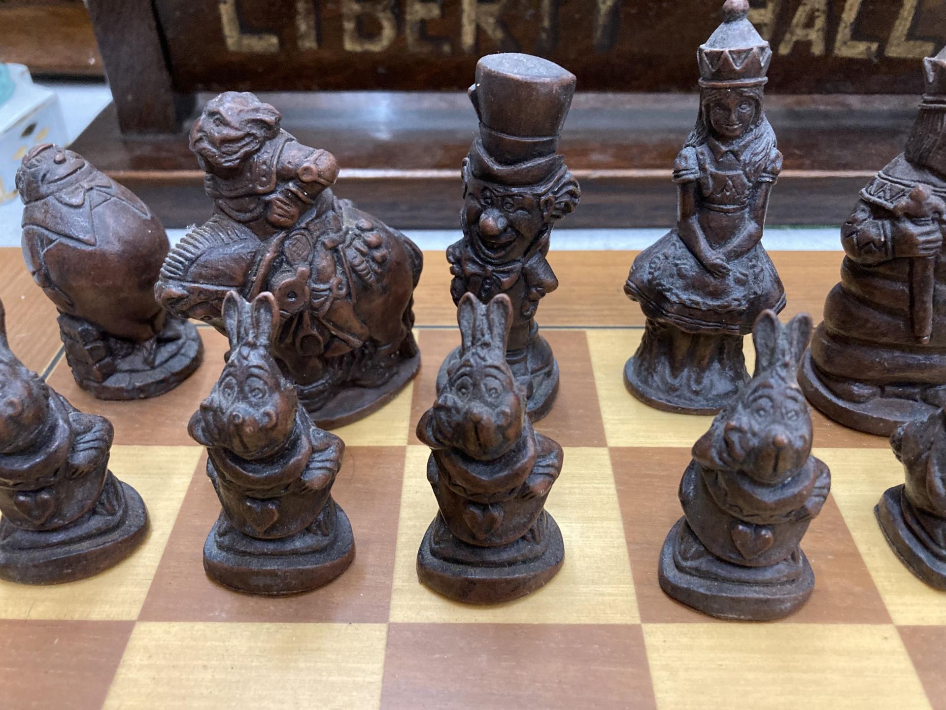 A CHESS SET WITH A WOODEN BOARD AND ALICE IN WONDERLAND THEMED PLAYING PIECES - Bild 2 aus 3