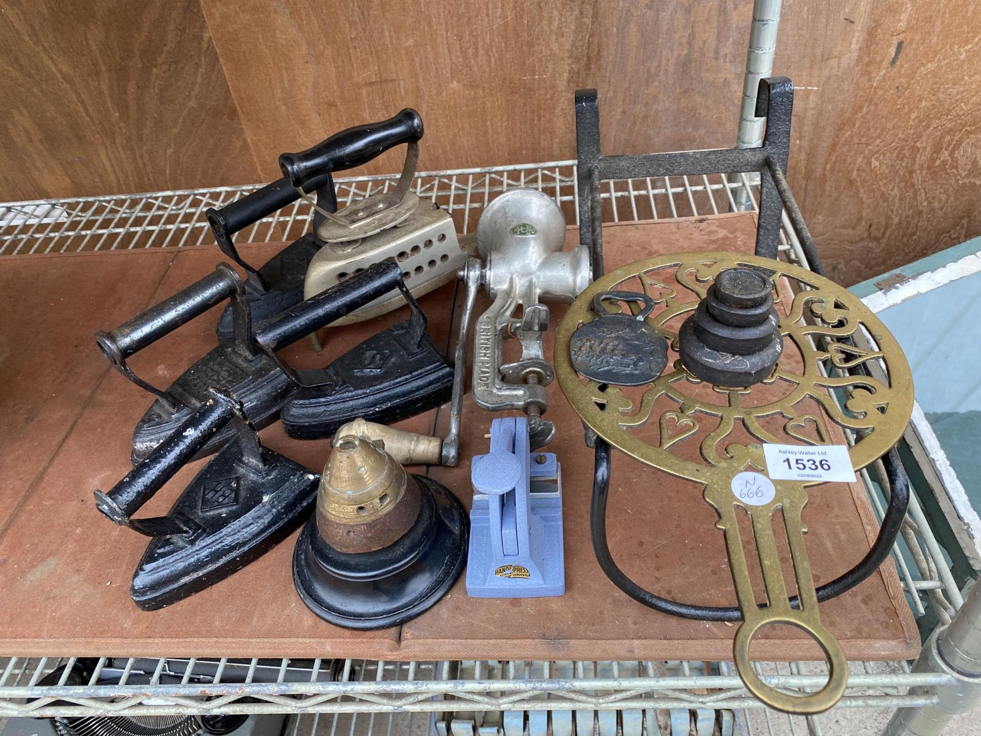 AN ASSORTMENT OF VINTAGE ITEMS TO INCLUDE FOUR FLAT IRONS, A BRASS TOPPED INK WELL AND A TRIVET