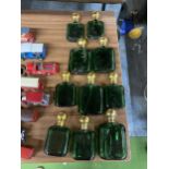 A COLLECTION OF GREEN GLASS AND BRASS TOPPED BOTTLES