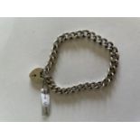 A HEAVY SILVER BRACELET WITH A HEART PADLOCK