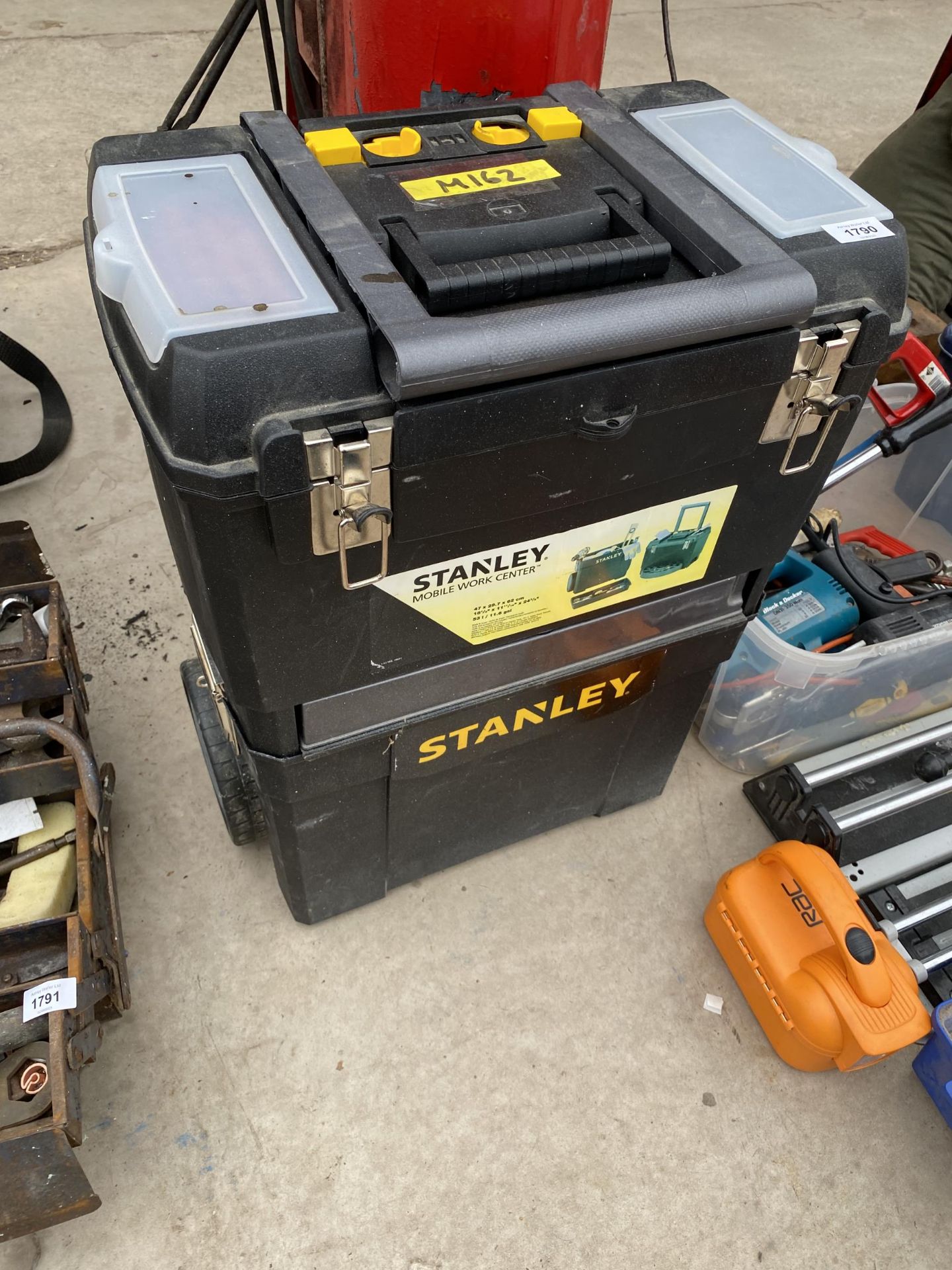 A PLASTIC STANLEY STACKING TOOL BOX WITH TROLLEY WHEELS AND AN ASSORTMENT OF TOOLS TO INCLUDE FILES,