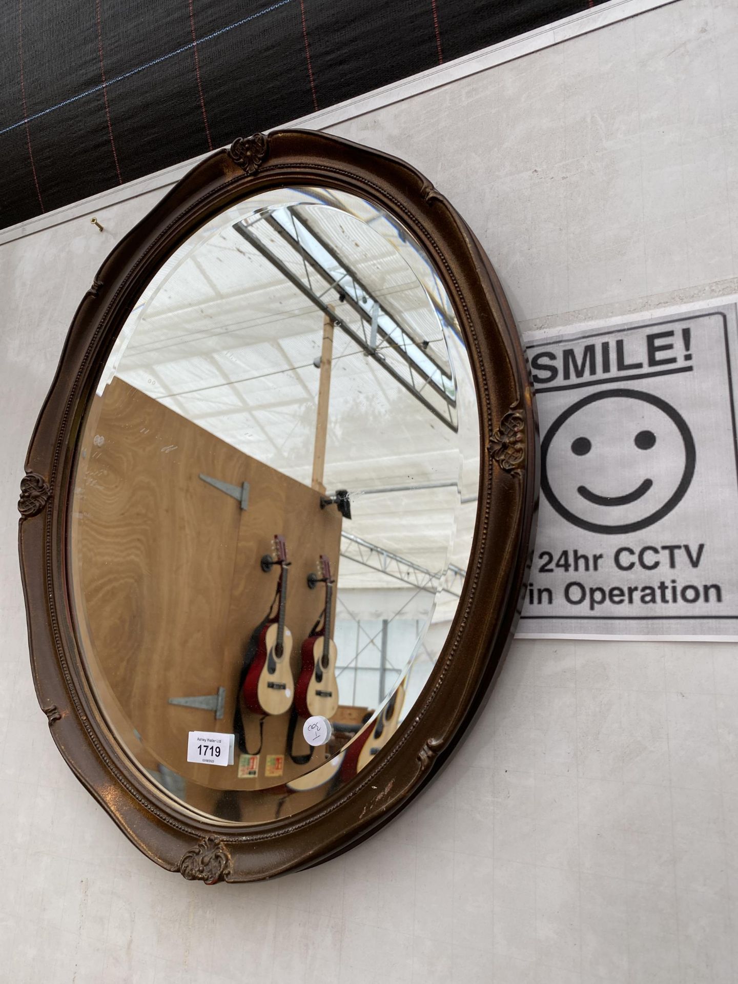 AN OAK FRAMED BEVELED EDGE WALL MIRROR