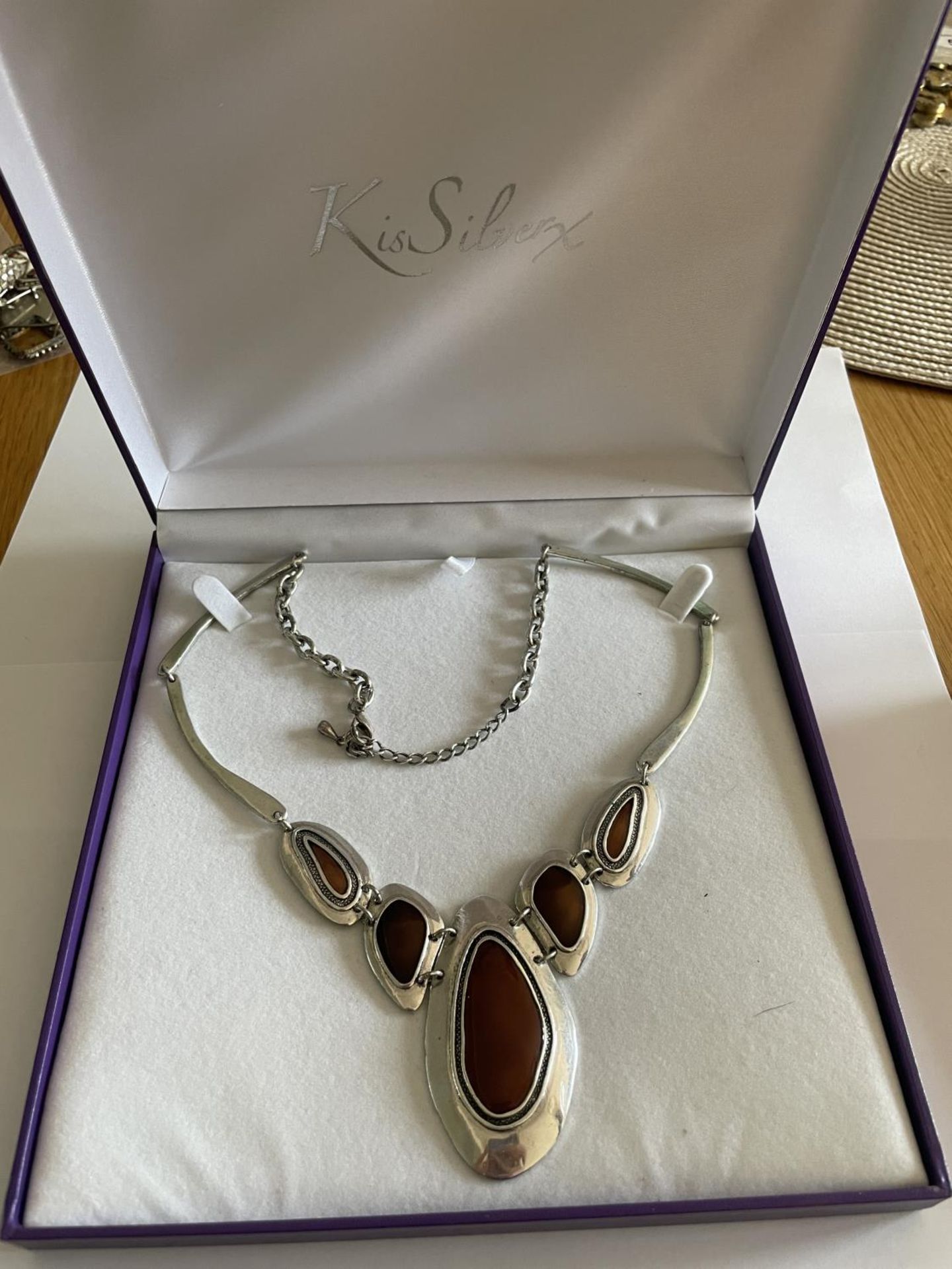 A SILVER ABSTRACT DESIGN NECKLACE WITH AMBER COLOURED STONES IN A PRESENTATION BOX