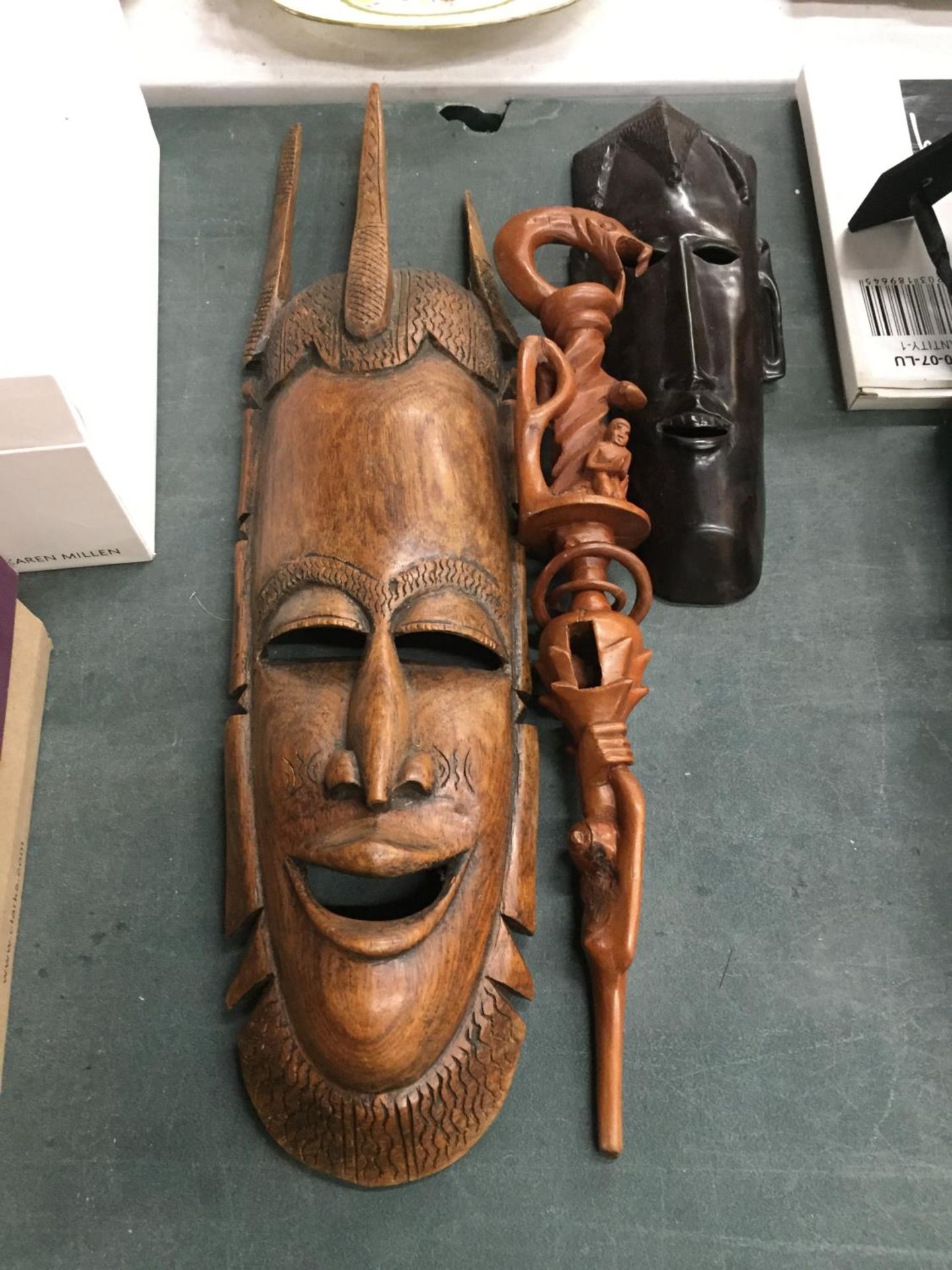 TWO AFRICAN STYLE FACE MASKS PLUS A TRIBAL STYLE CARVED STICK WITH SERPENT DESIGN