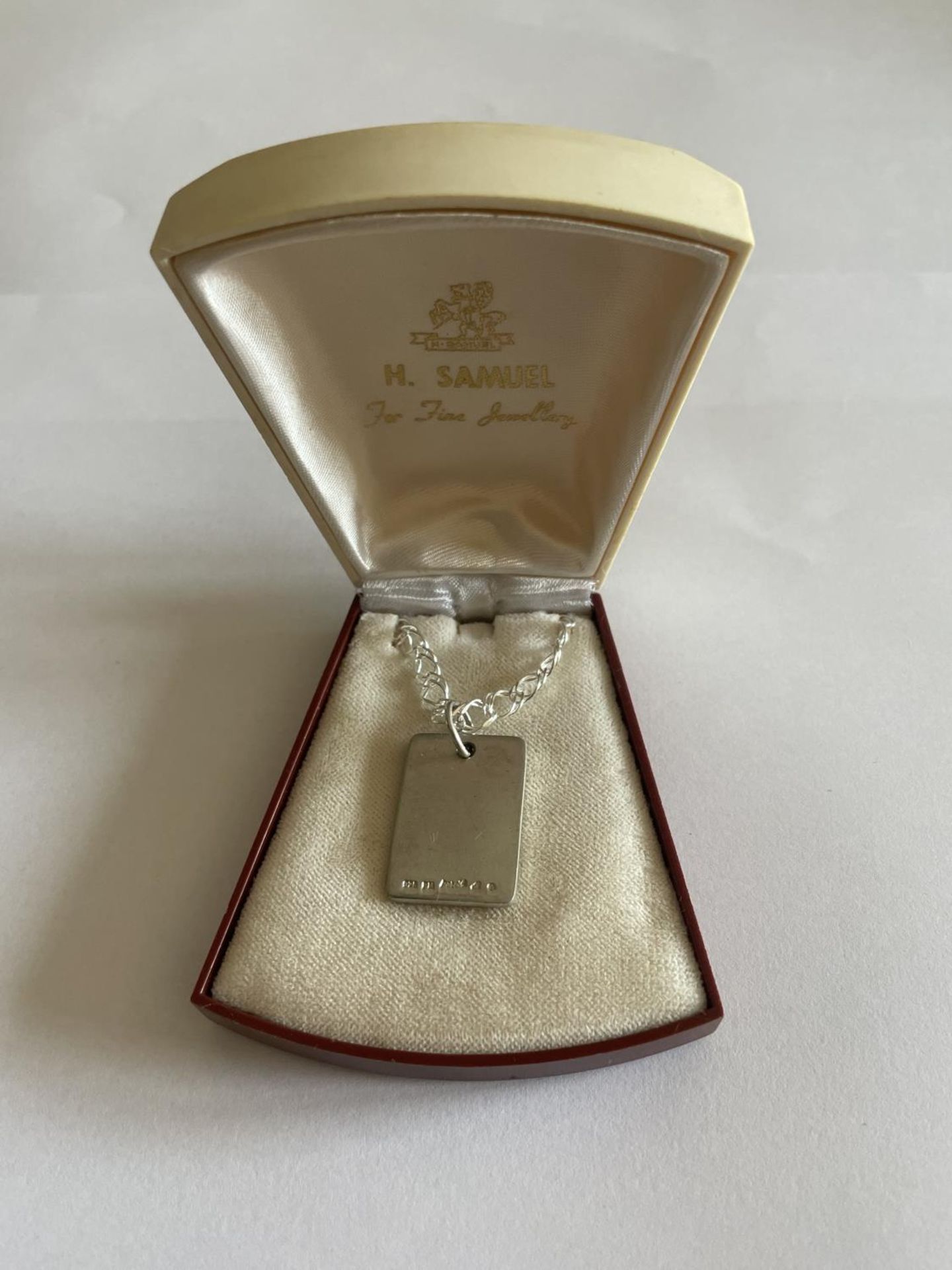 A SILVER NECKLACE WITH INGOT PENDANT IN A PRESENTATION BOX