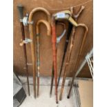 AN ASSORTMENT OF WALKING STICKS TO INCLUDE TWO SWAGGER STICKS ONE WITH A STERLING SILVER COLLAR