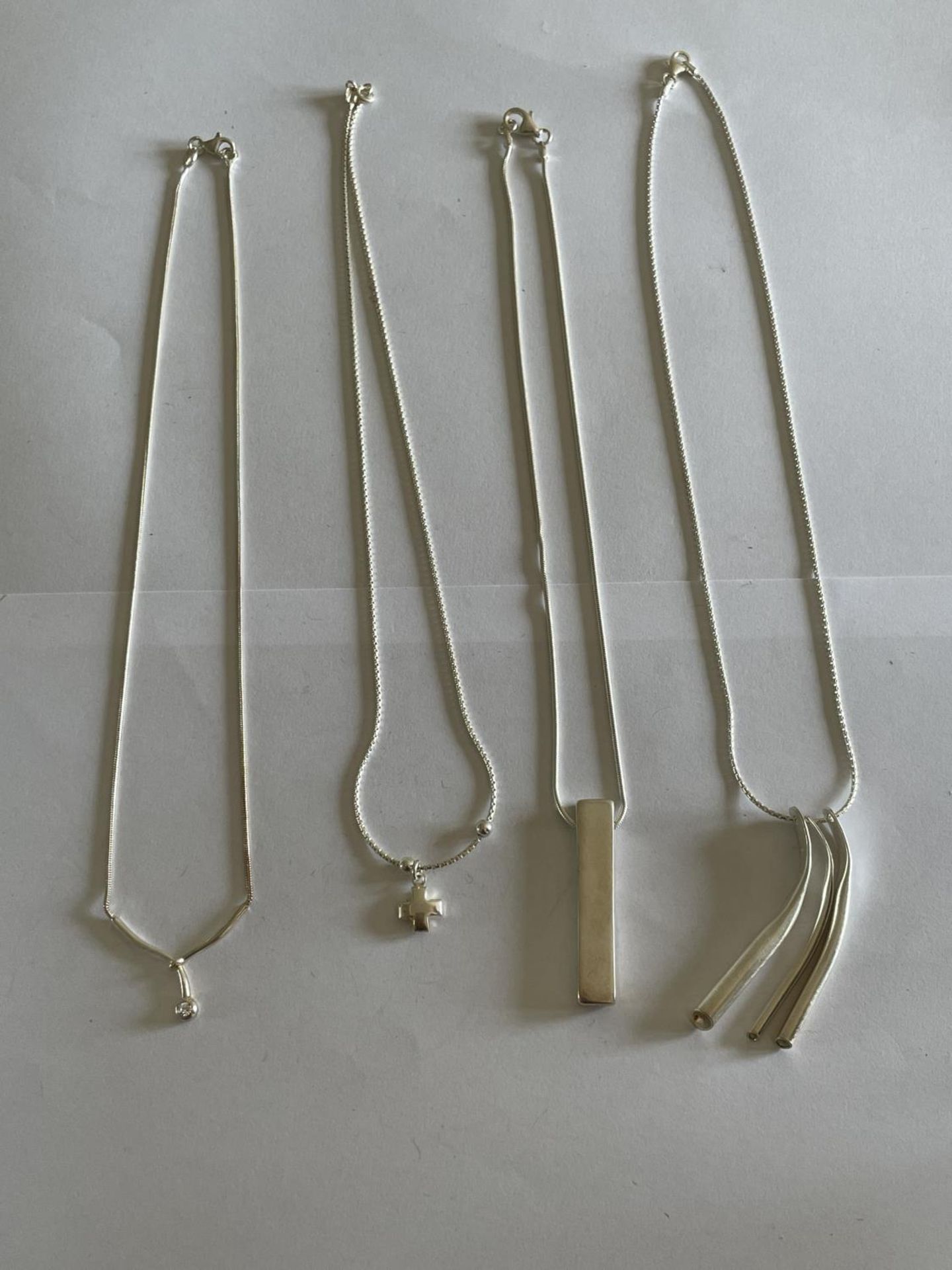 FOUR SILVER NECKLACES WITH PENDANTS