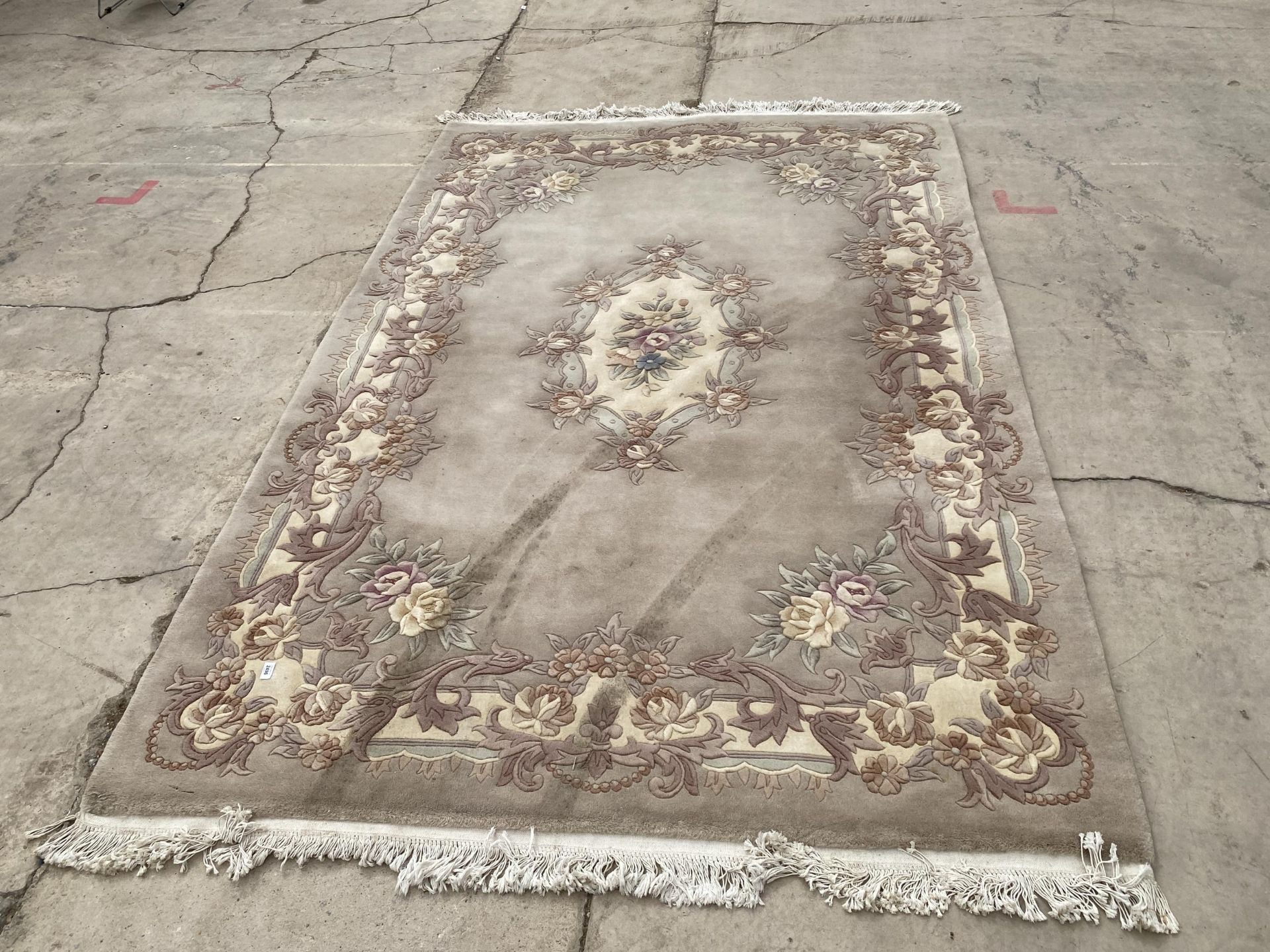 A LARGE PEACH COLOURED FRINGE PATTERNED RUG