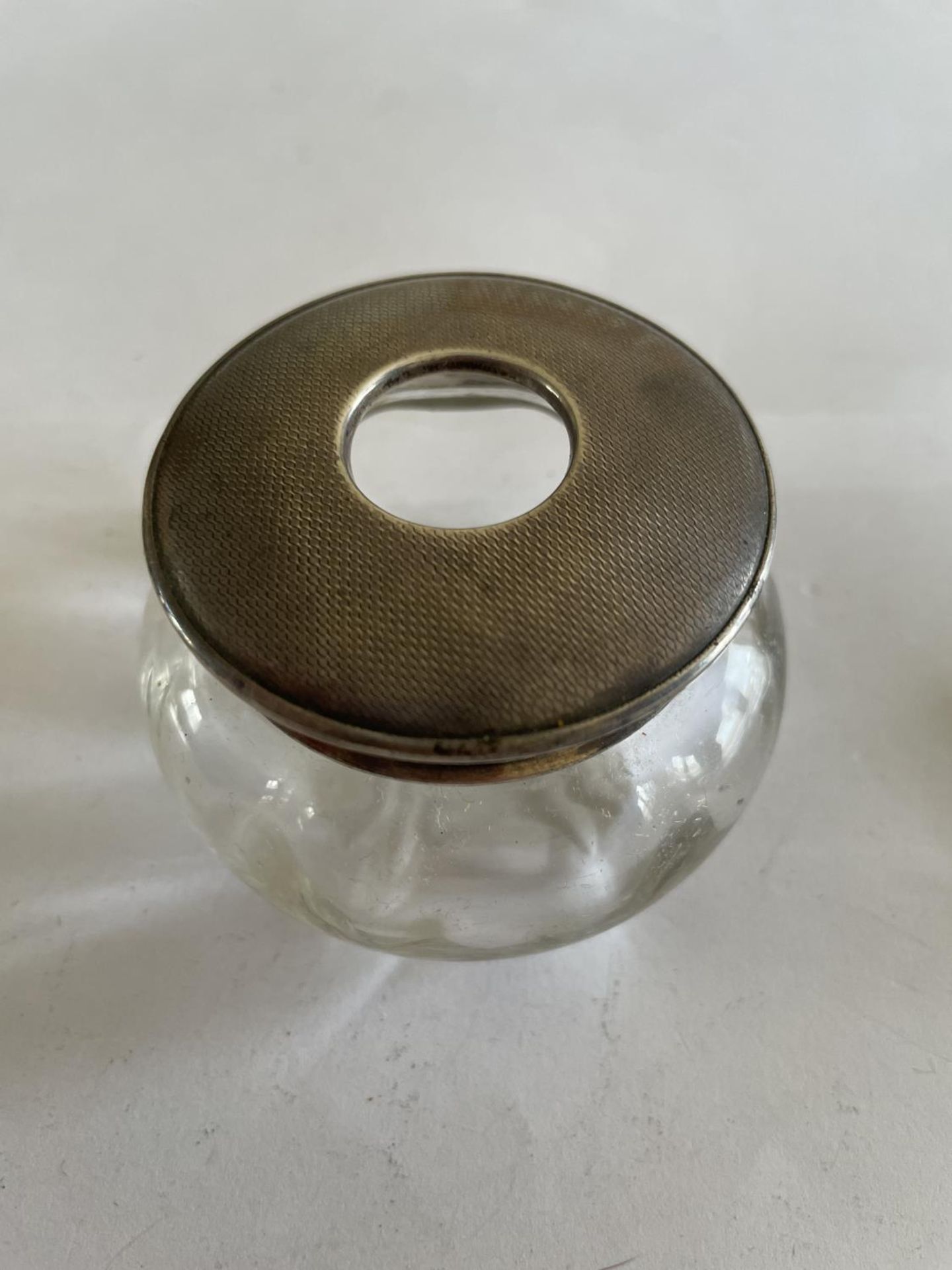 A GLASS POT WITH A HALLMARKED LONDON SILVER LID