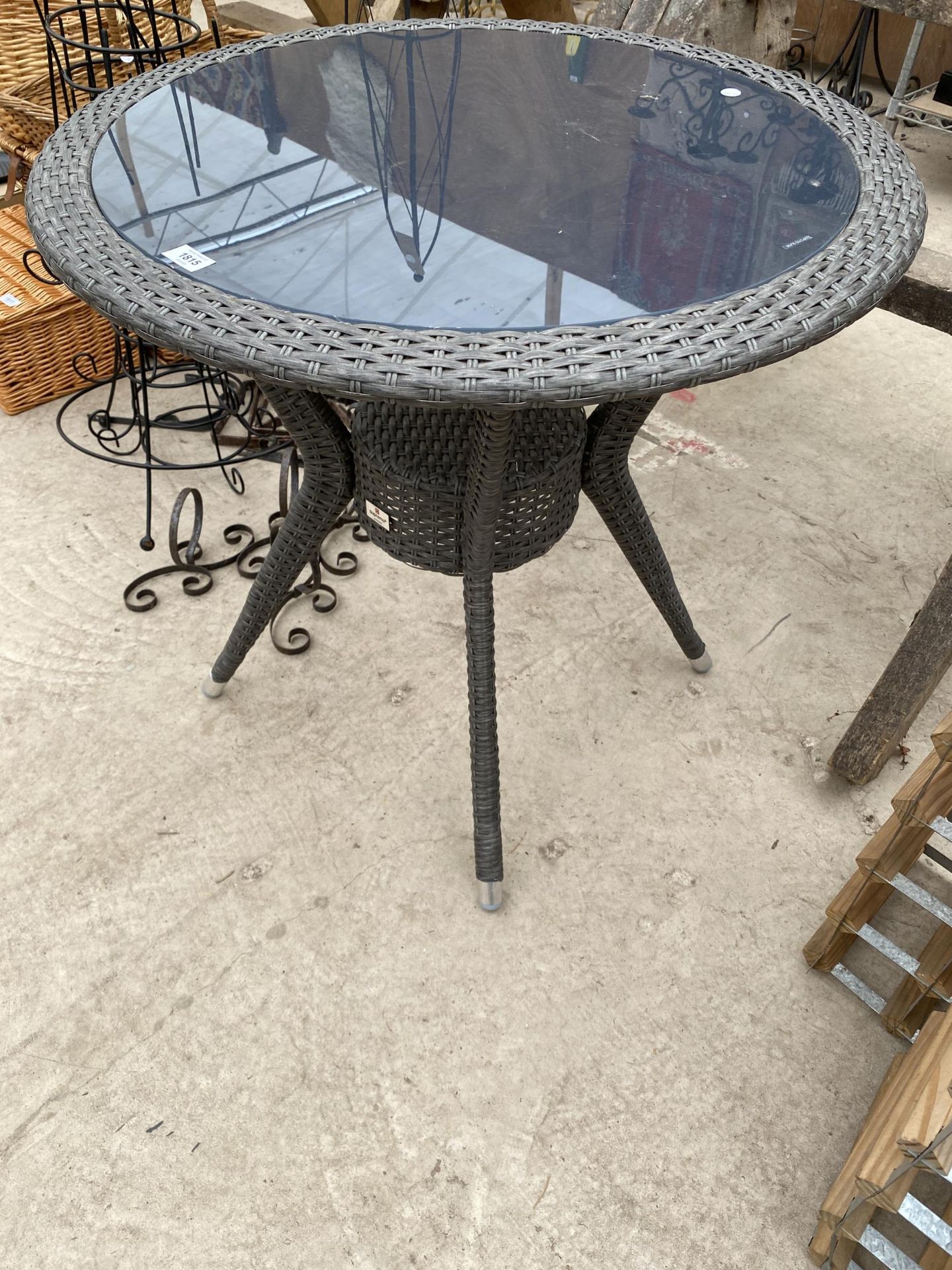 A RATTAN GLASS TOPPED BISTRO TABLE