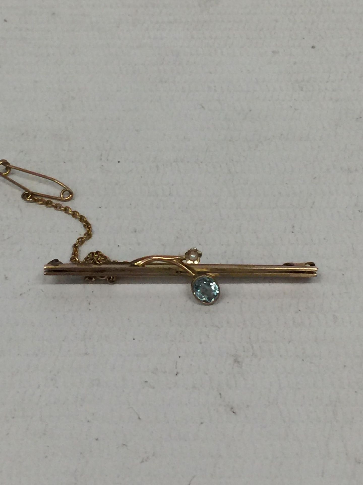 A BLUE STONE 9CT GOLD PIN