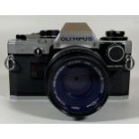 A VINTAGE OLYMPUS OM10 CAMERA FITTED WITH ZUIKO MC AUTO 50MM LENS