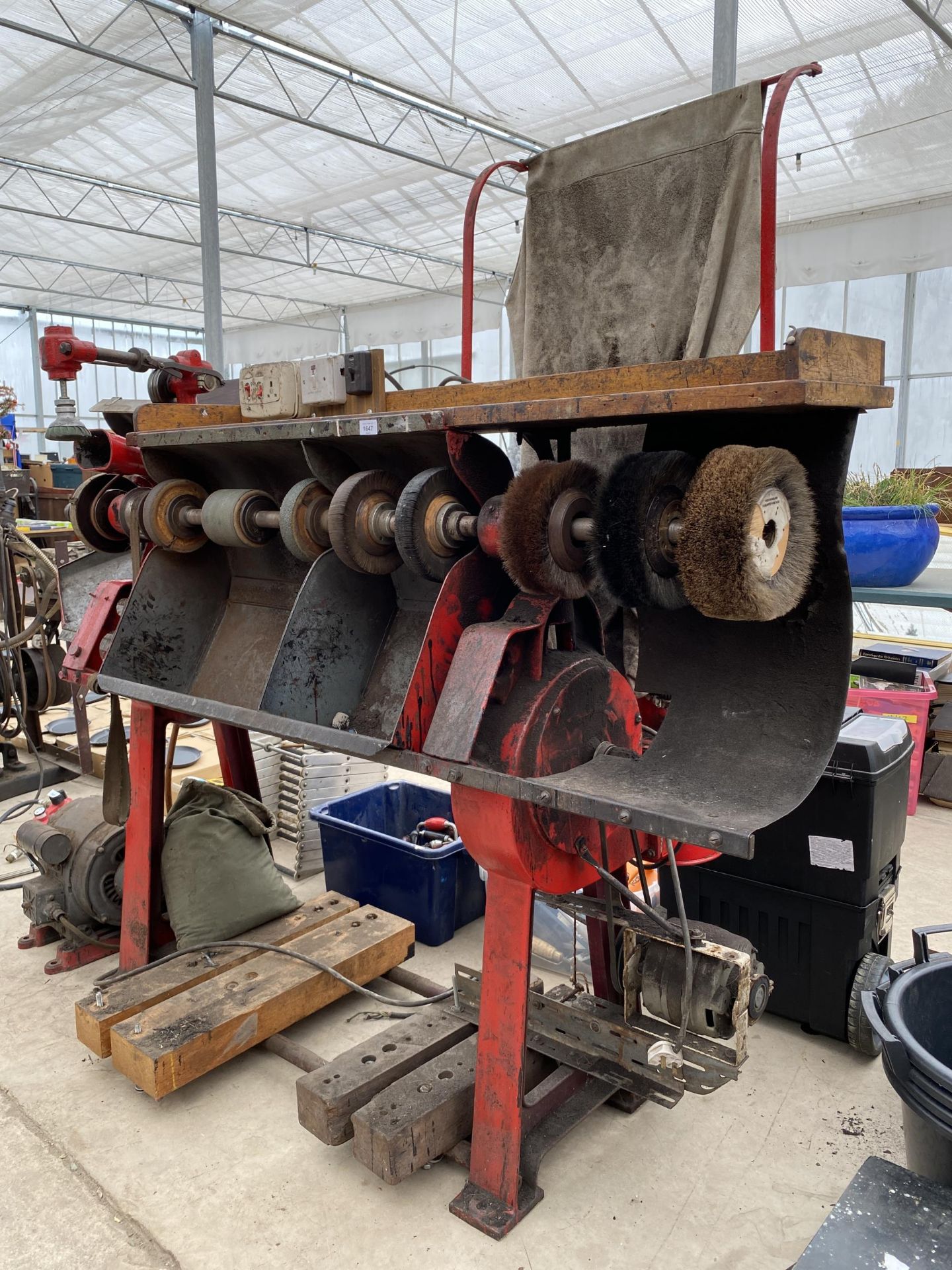 A LARGE INDUSTRIAL SHOE SHINING MACHINE WITH VARIOUS BRUSHES