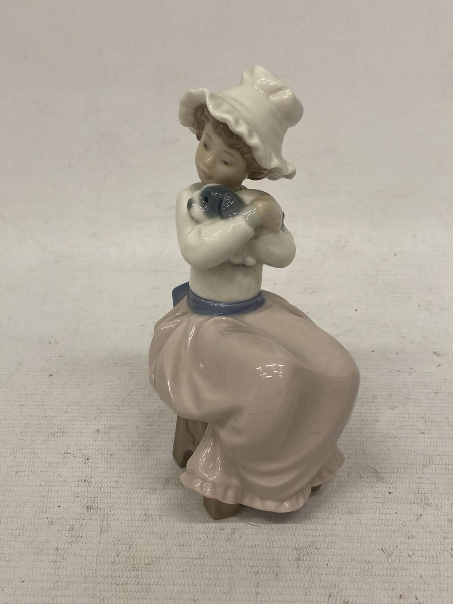 A NAO FIGURINE OF A GIRL HUGGING HER DOG - Image 2 of 4