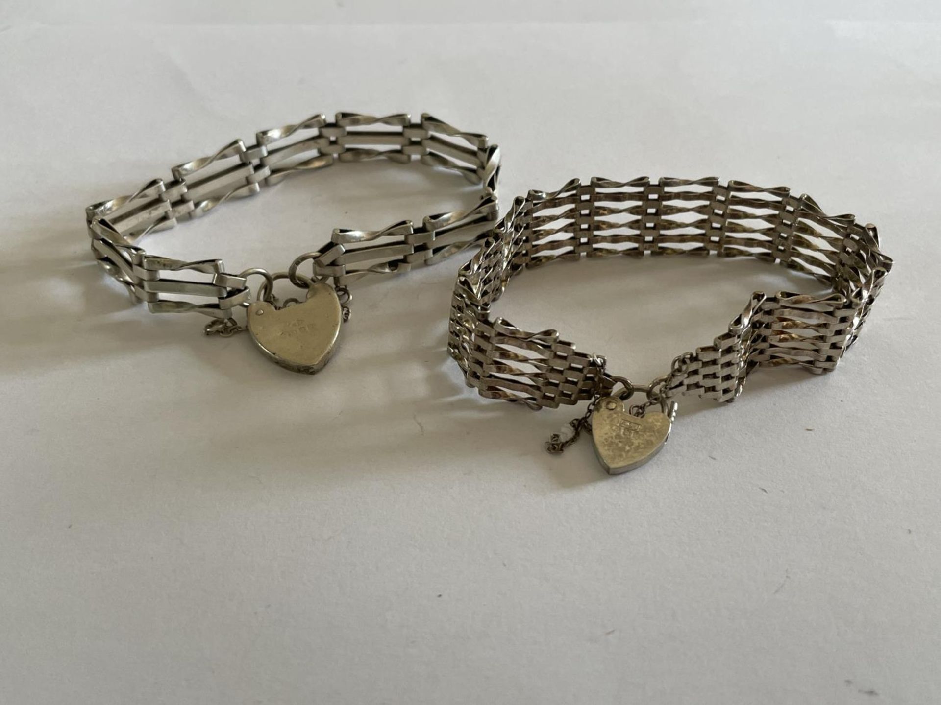 TWO SILVER GATE BRACELETS ONE SIX BAR AND ONE THREE
