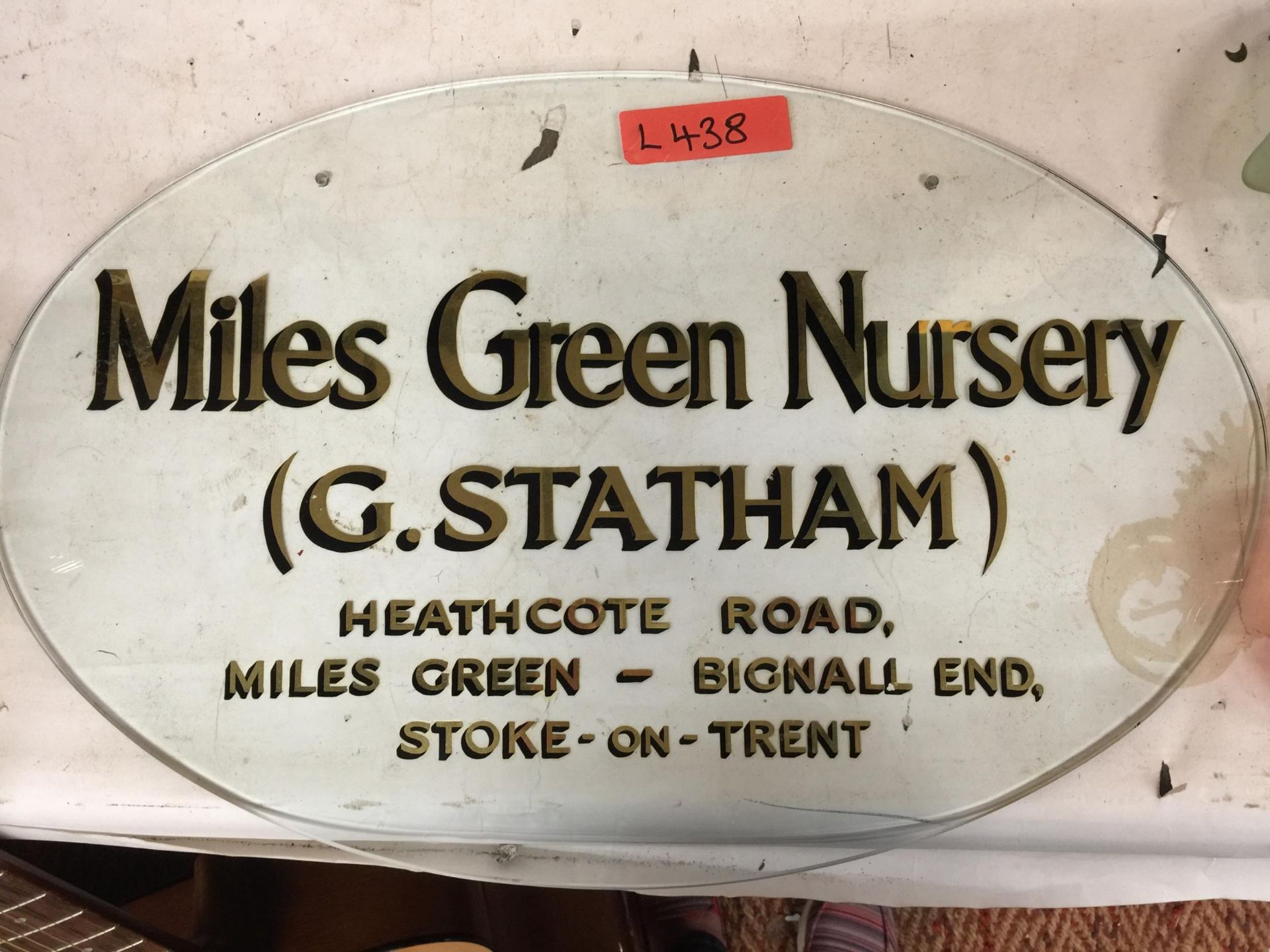 A GLASS OVAL SIGN WITH GOLD COLOURED WRITING 'MILES GREEN NURSERY' DIAMETER 56CM