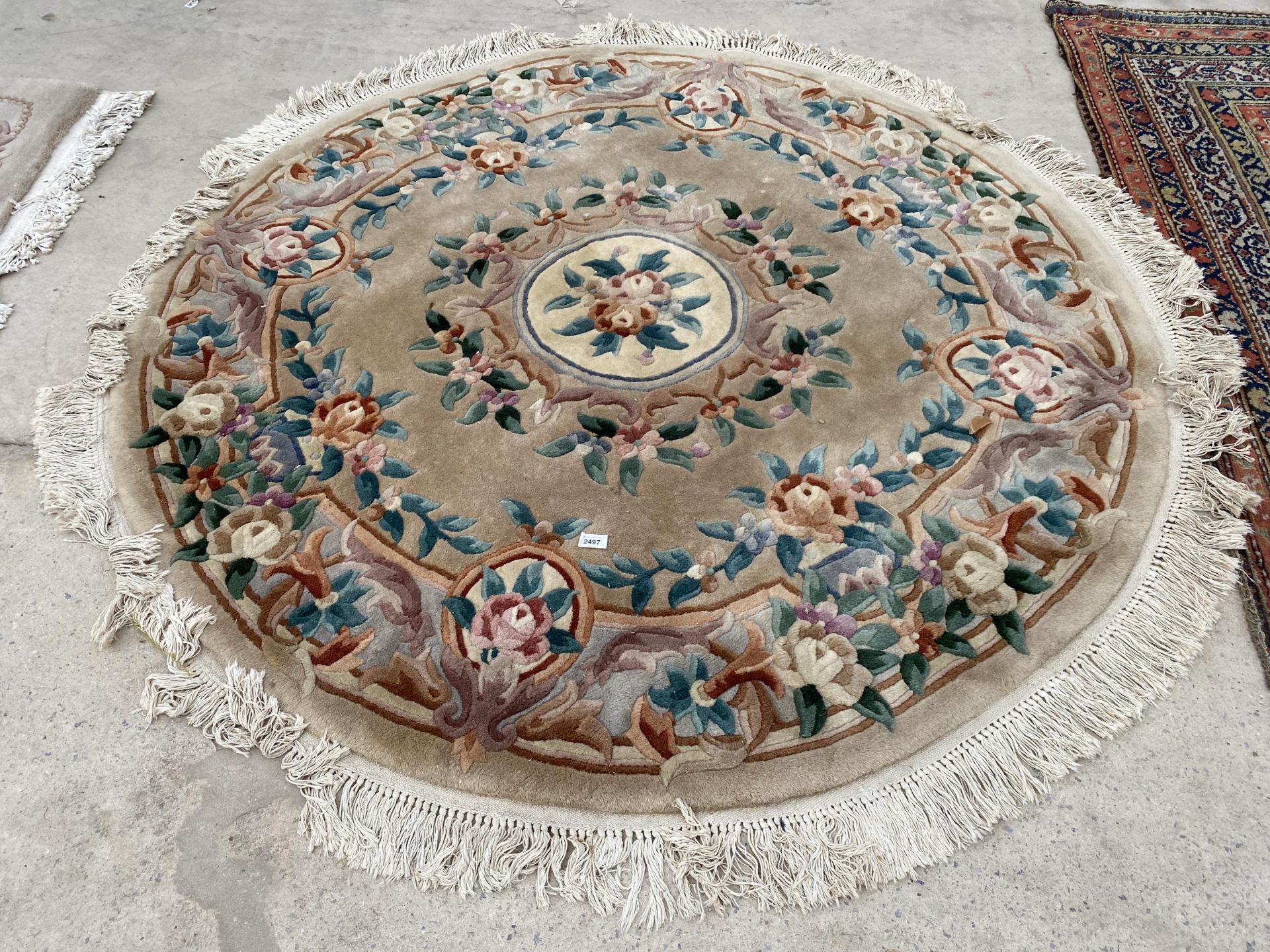 A CIRCULAR PEACH PATTERNED FRINGED RUG