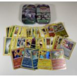 TWO TINS OF POKEMON TRADING CARDS INCLUDING HOLOS