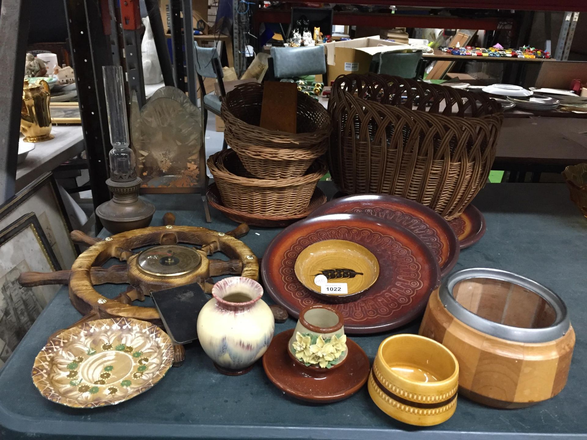 A MIXED VINTAGE LOT TO INCLUDE BRASS OIL LAMP, WICKER BASKETS, SHIPS WHEEL BAROMETER ETC
