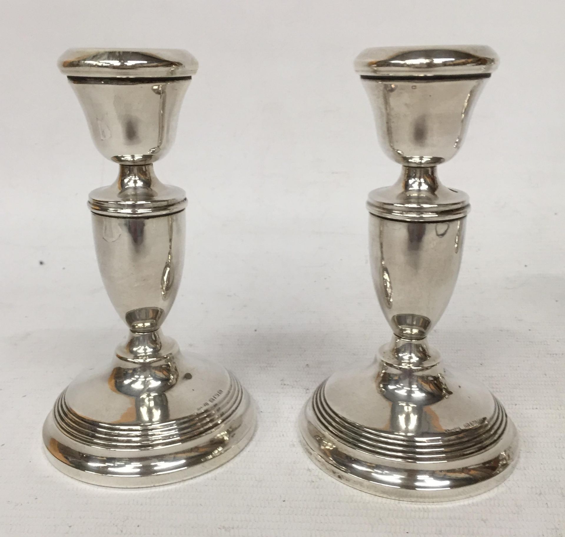 A PAIR OF HALLMARKED SILVER CANDLESTICKS, (WEIGHTED BASES)