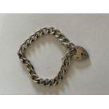 A HEAVY SILVER BRACELET WITH HEART PADLOCK