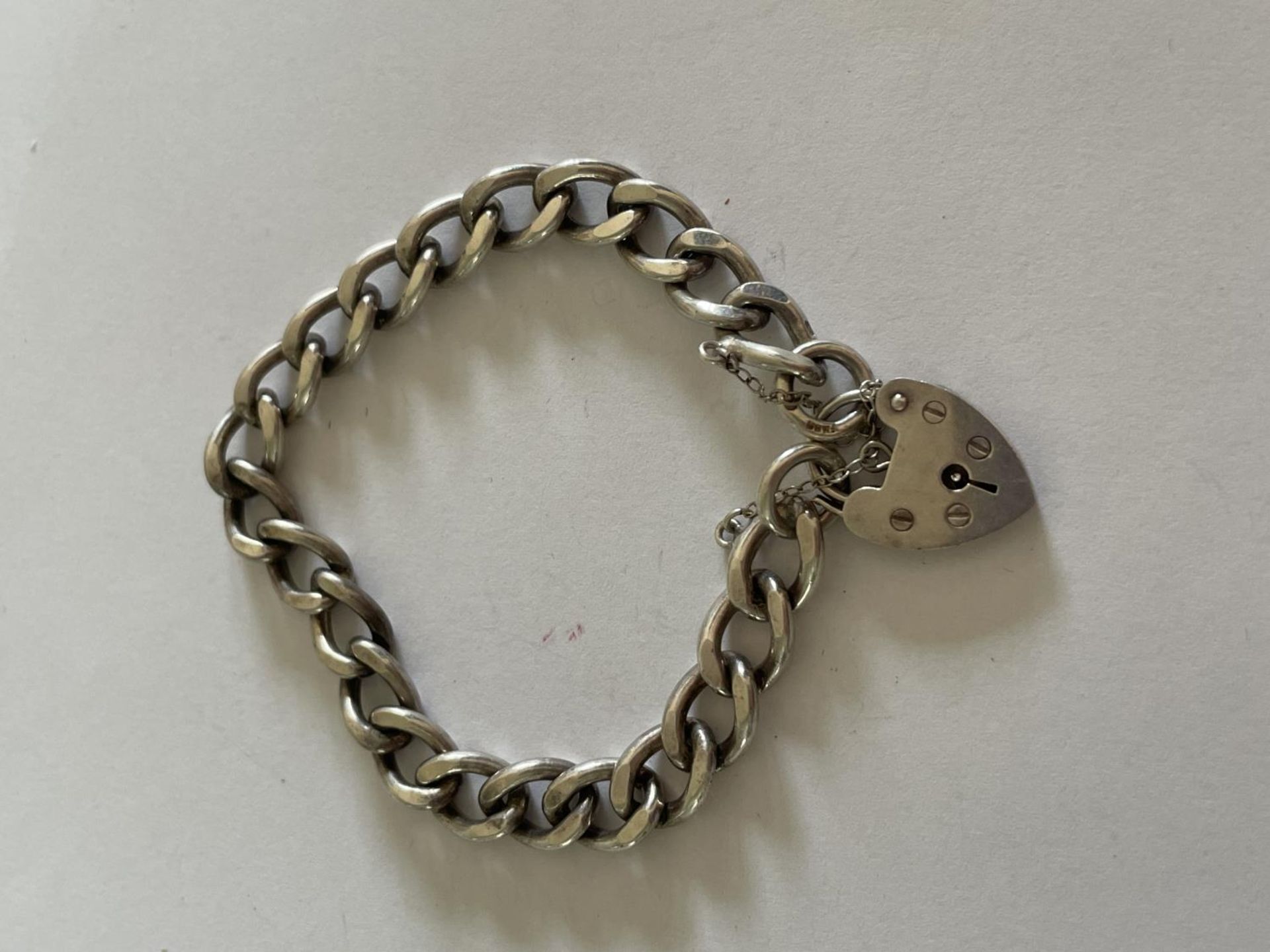 A HEAVY SILVER BRACELET WITH HEART PADLOCK