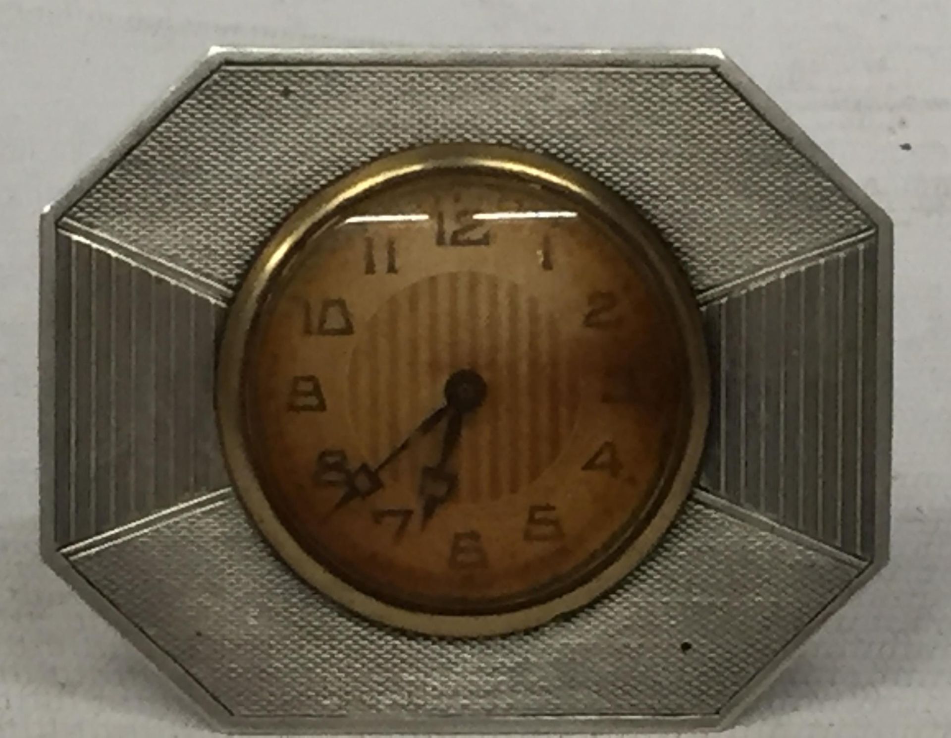 AN ART DECO HALLMARKED SILVER CLOCK WITH ENGINE TURNED DESIGN