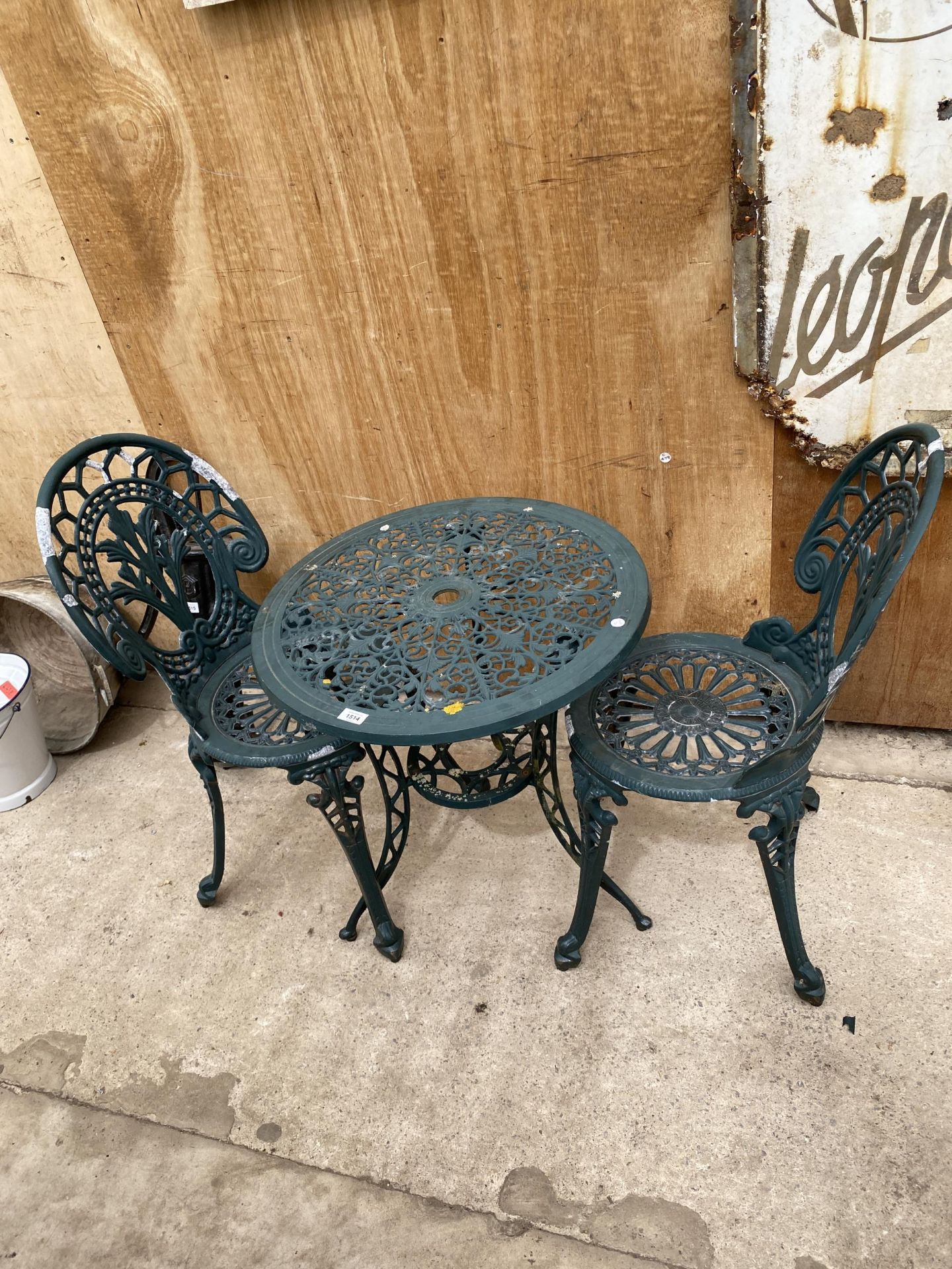 A VINTAGE CAST ALLOY BISTRO SET COMPRISING OF A ROUND TABLE AND TWO CHAIRS