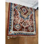 A MULTI COULOURED PATTERNED FRINGED RUG