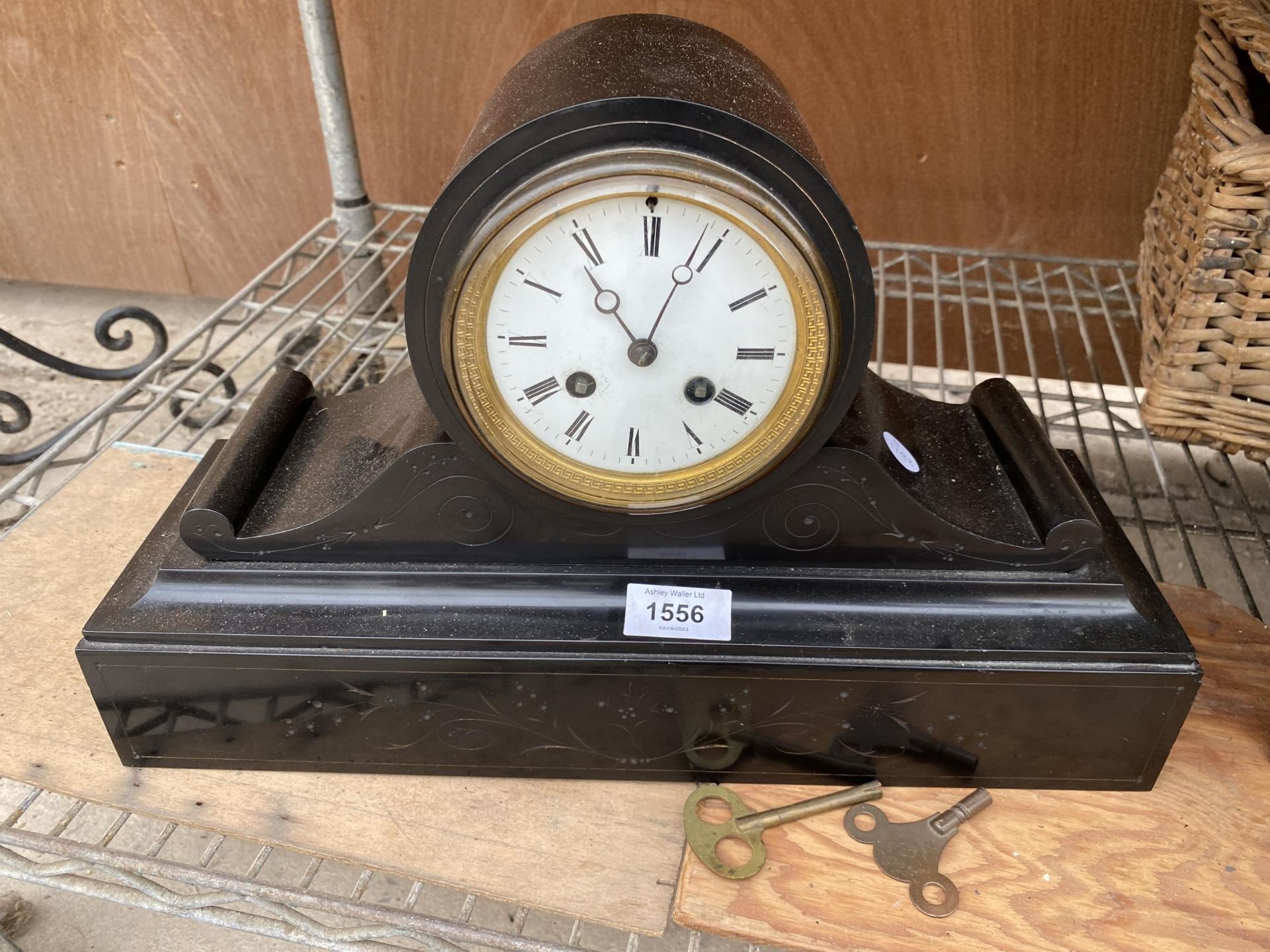 A DECORATRIVE POSSIBLY MARBEL MANTLE CLOCK WITH KEYS