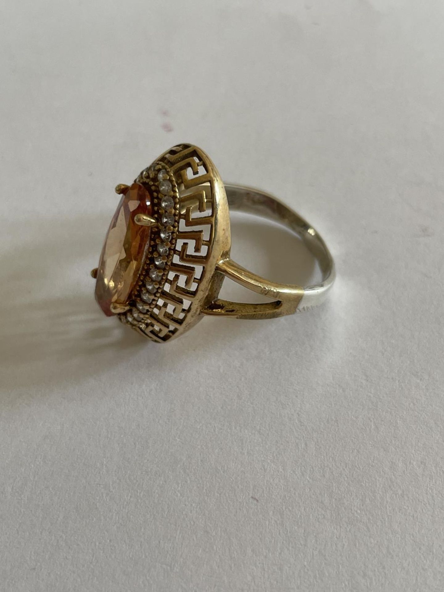 A DECORATIVE SILVER AND GOLD RING WITH LARGE AMBER COLOURED STONE SURROUNDED BY CLEAR STONES SIZE - Image 2 of 3