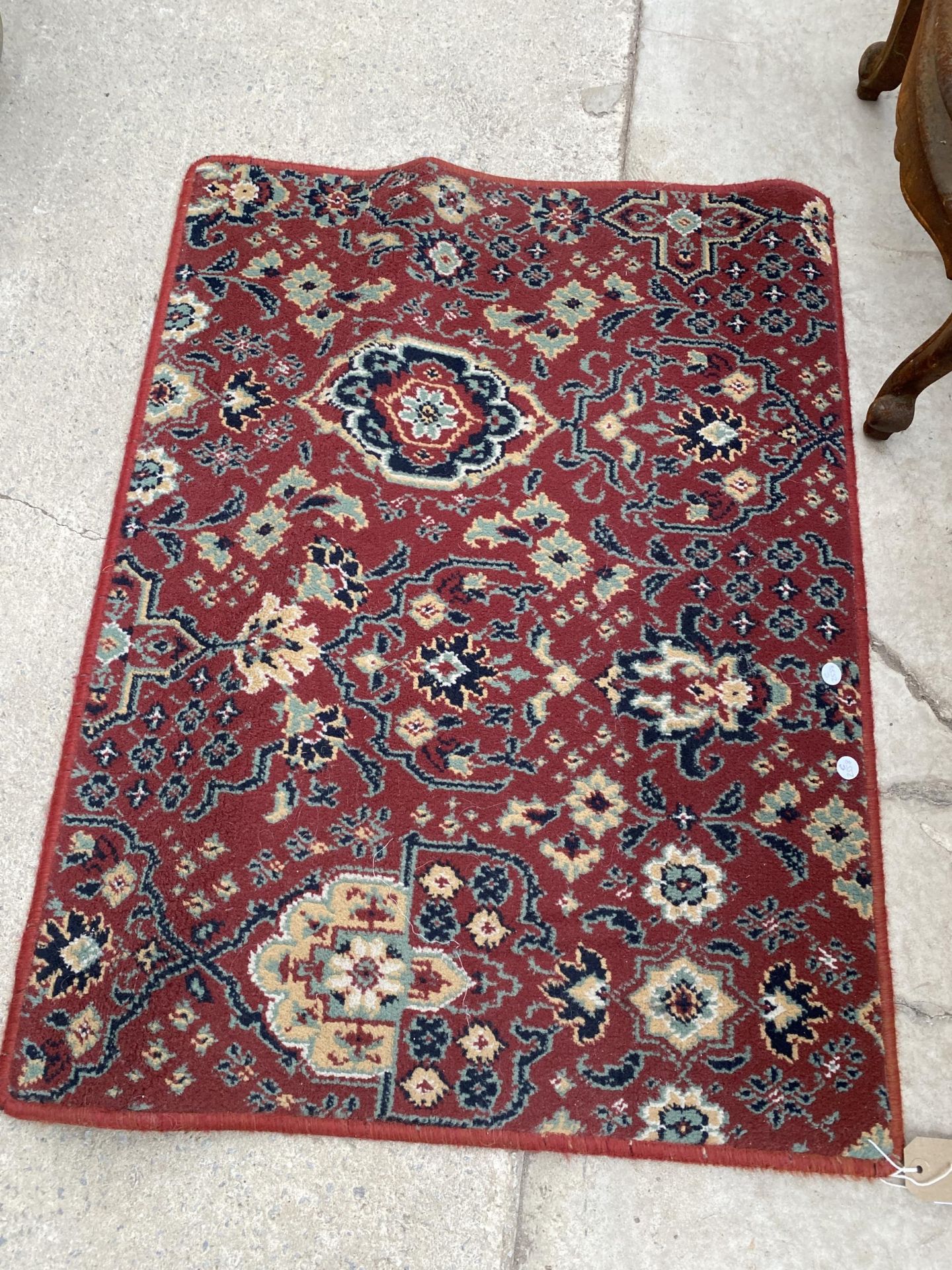 A SMALL RED PATTERNED RUG