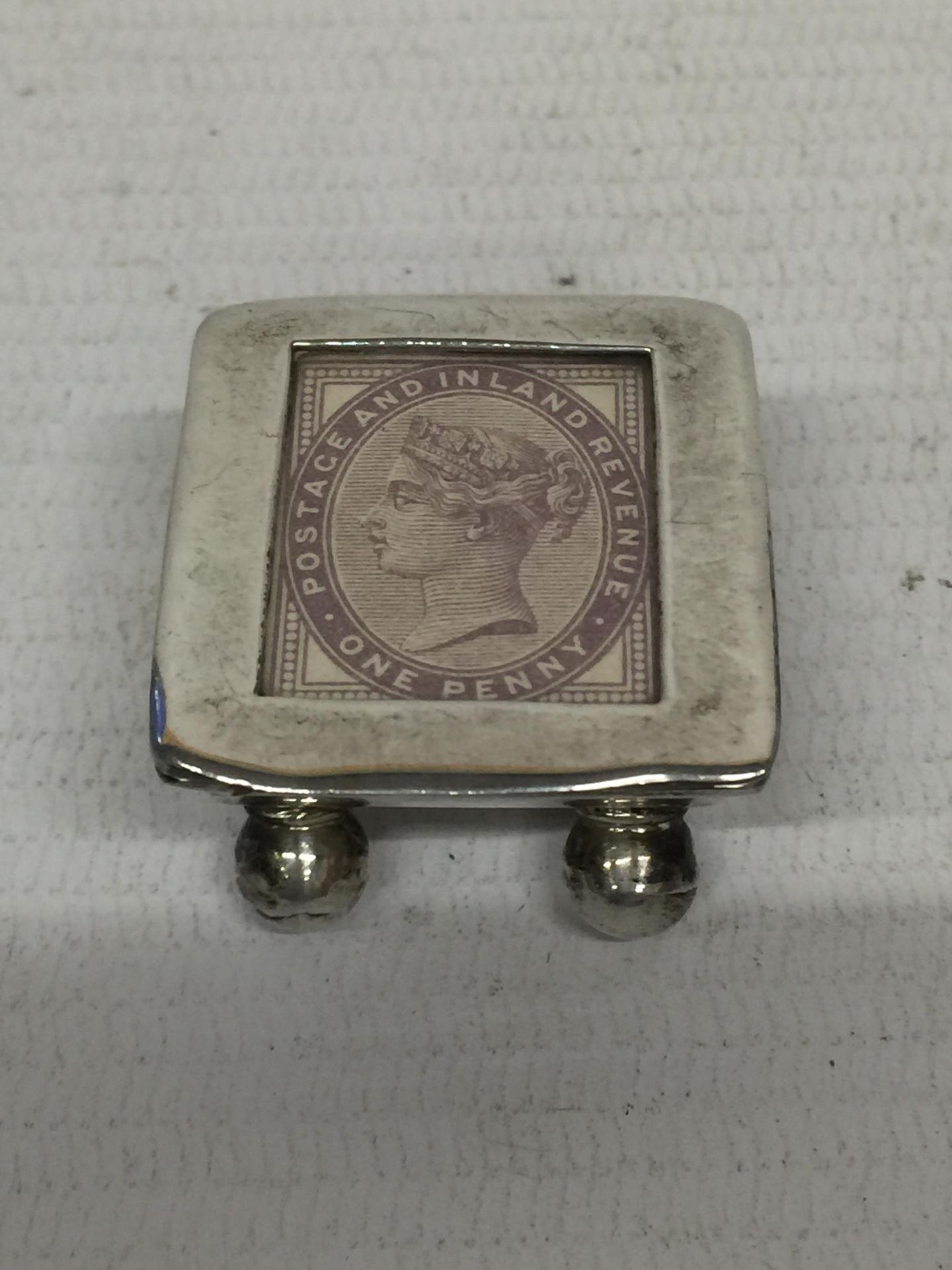 A SILVER TRINKET BOX WITH AN INLAID PENNY STAMP