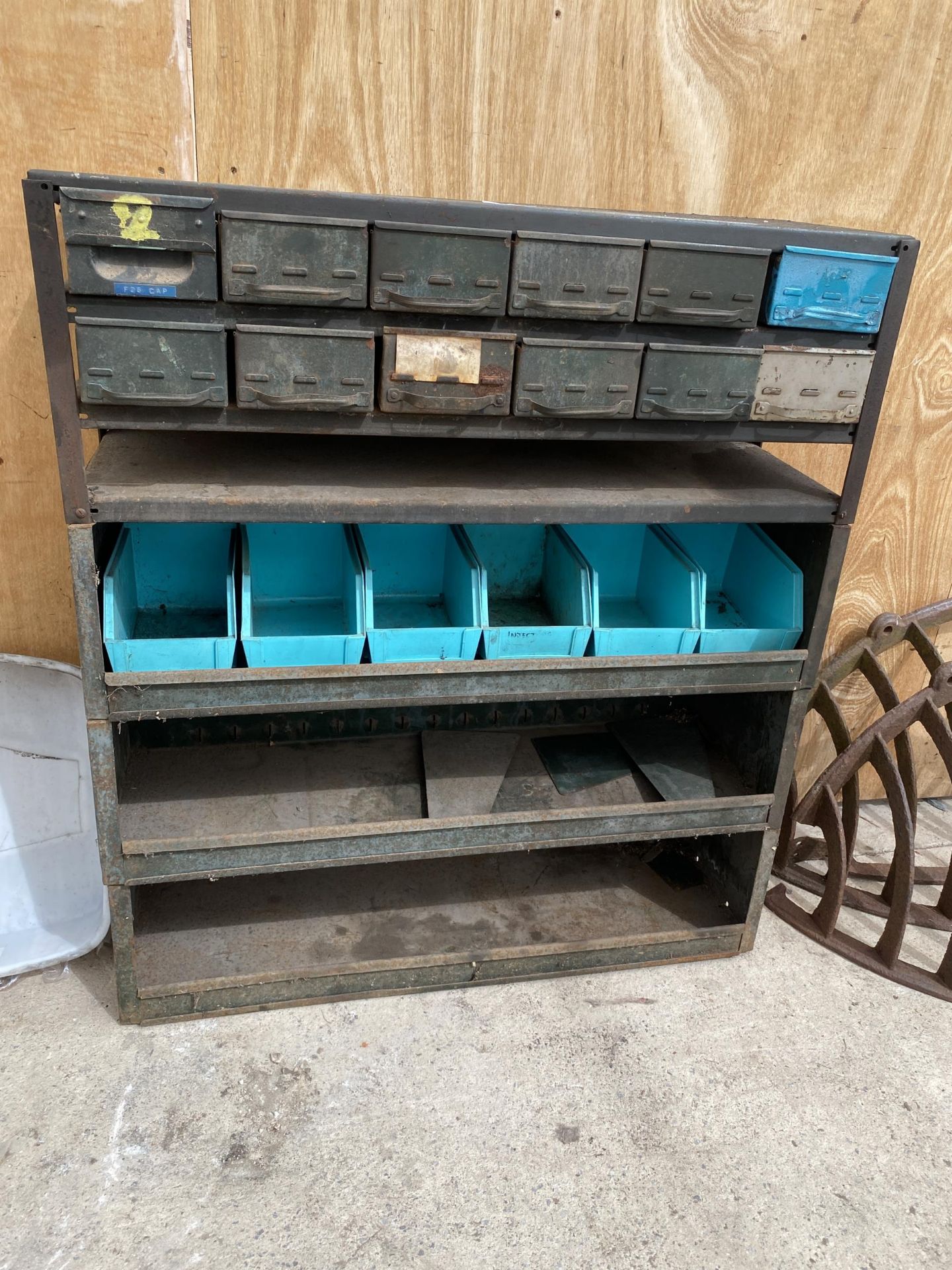 A VINTAGE TOOL STORAGE UNIT WITH UPPER INDIVIDUAL TRAY DRAWERS AND LOWER SHELVES