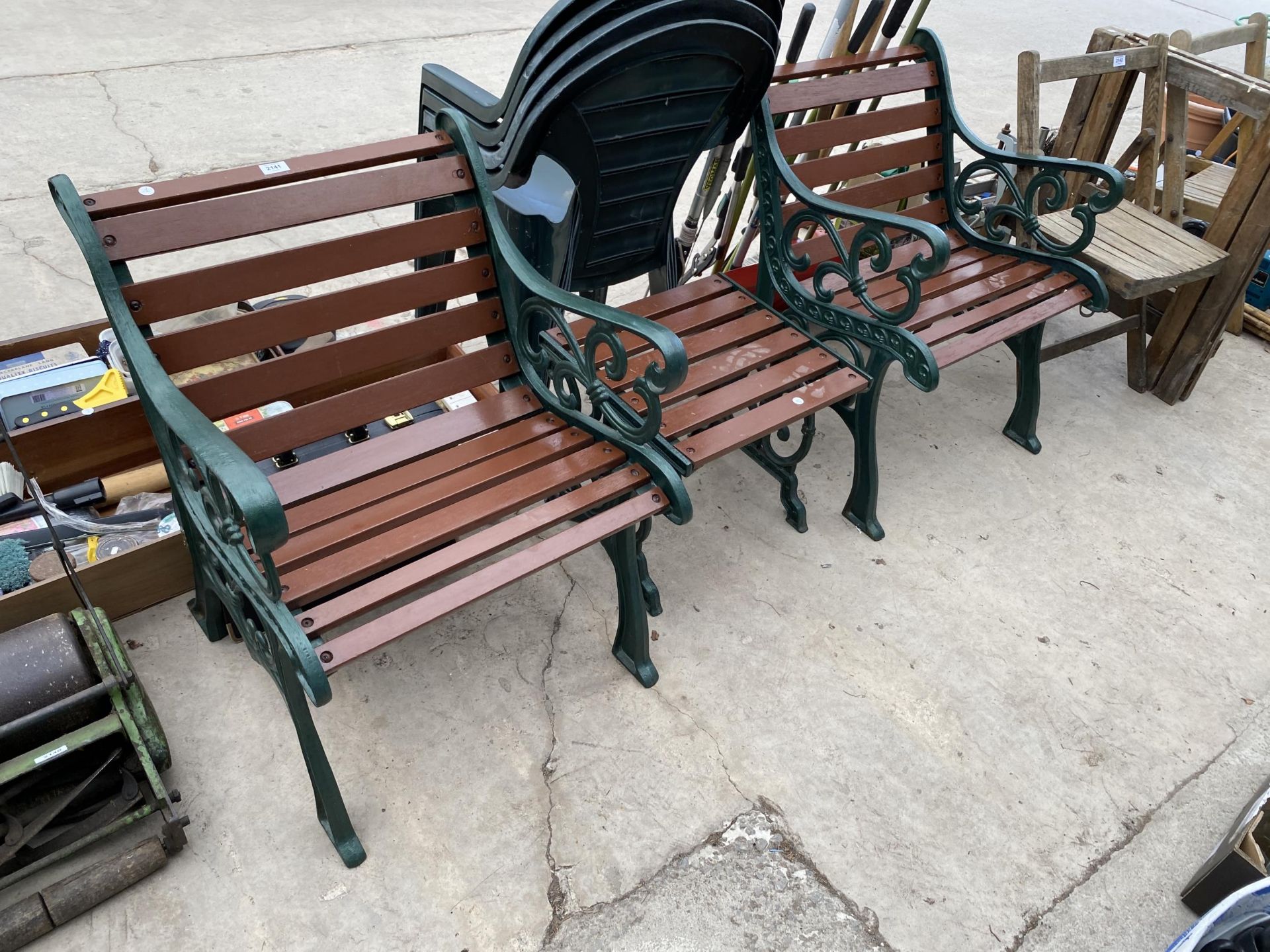 TWO WOODEN SLATED GARDEN CHAIRS AND A SIDE TABLE ALL WITH CAST IRON ENDS