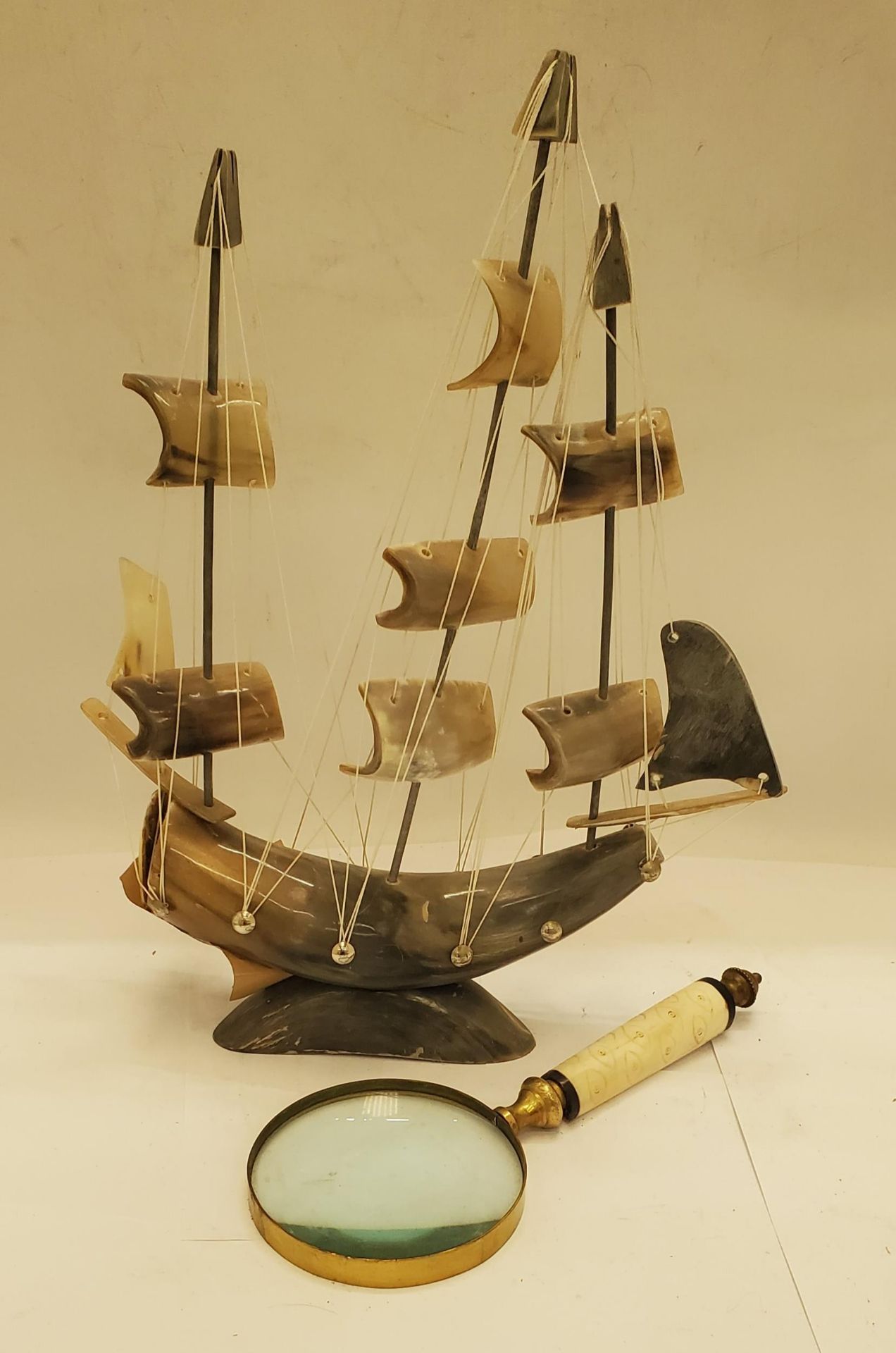 A VINTAGE BRASS AND CARVED BONE HANDLE PLUS A HORN MODEL OF A SAILING SHIP