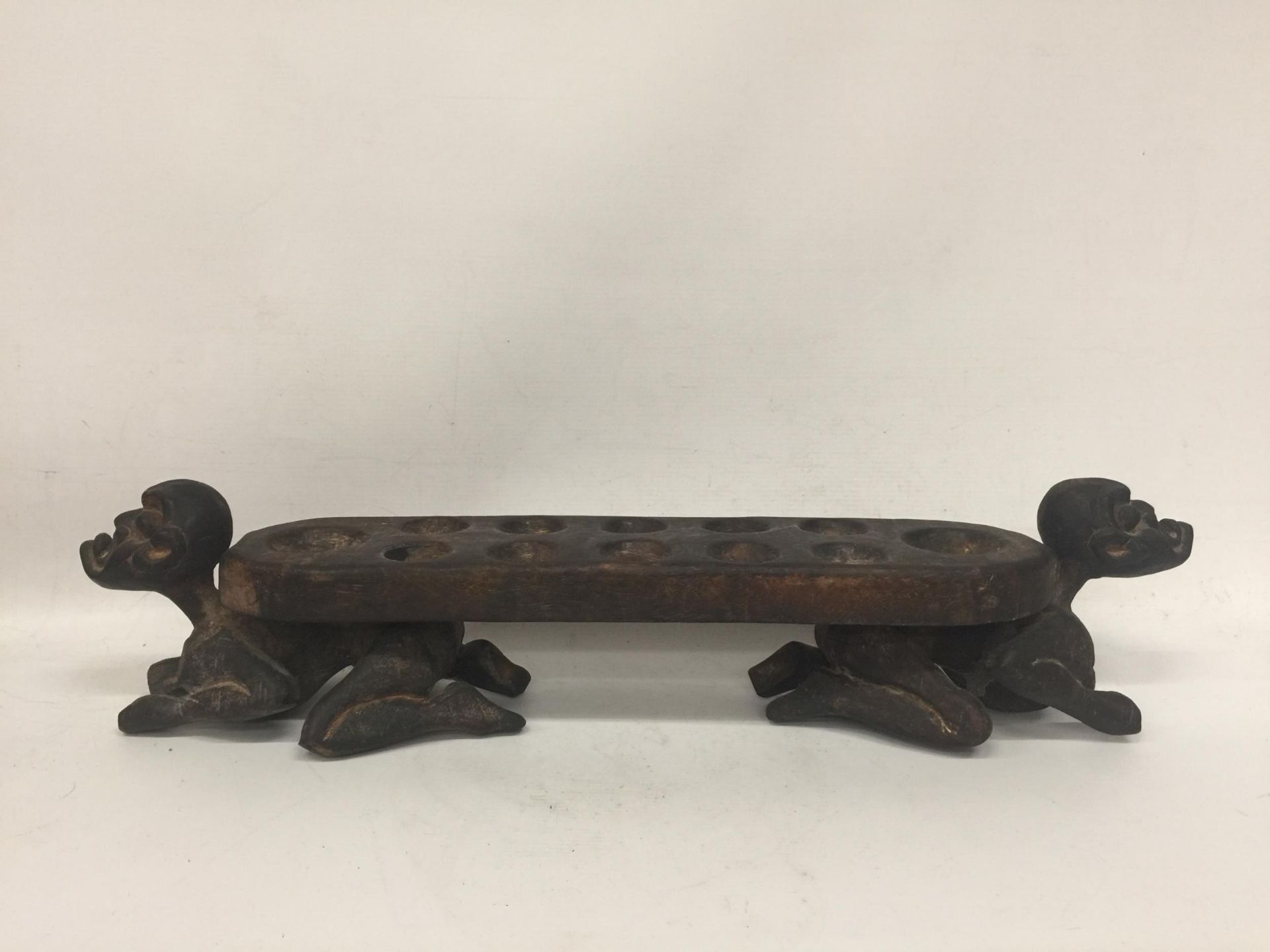 AN UNUSUAL TRIBAL WOODEN FIGURAL BALL STAND