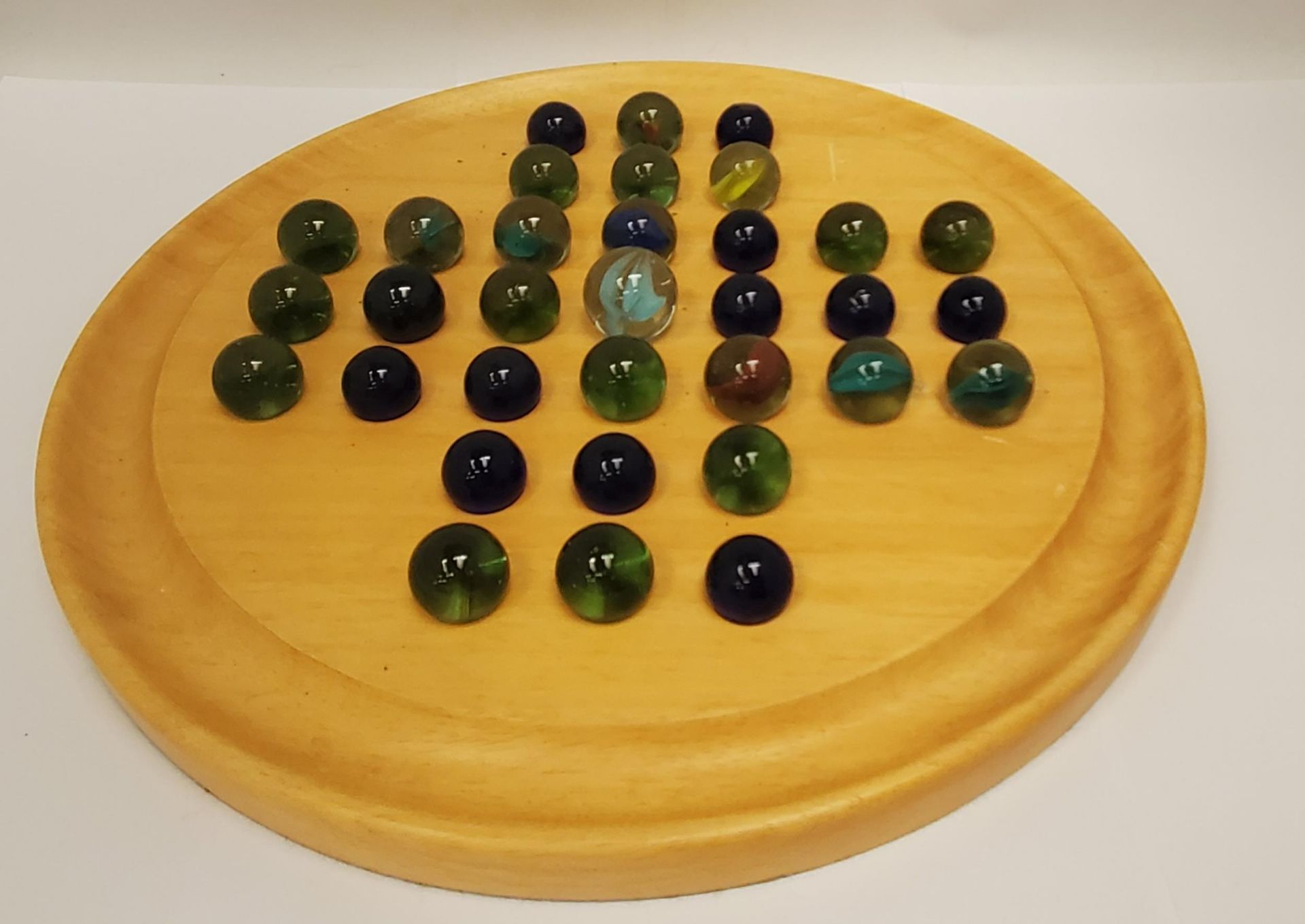 A LARGE WOODEN SOLITAIRE WITH VINTAGE MARBLES