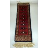 A VINTAGE MIDDLE EASTERN PERSIAN RED SAMPLE RUNNER, LENGTH 63CM