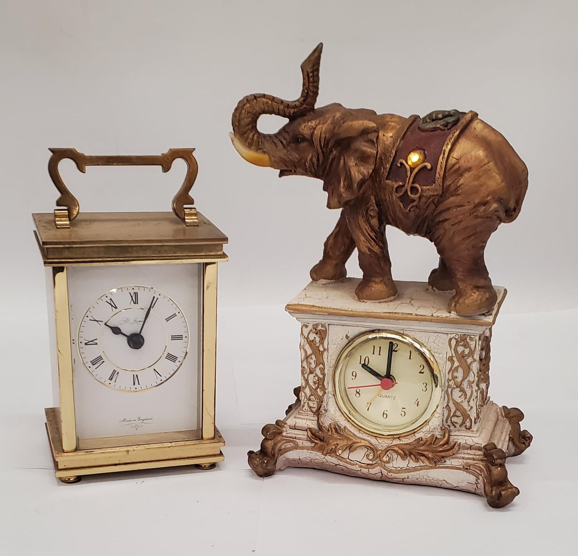 A VINTAGE ST. JAMES BRASS CARRIAGE CLOCK PLUS A MANTLE CLOCK WITH AN ELEPHANT ON TOP