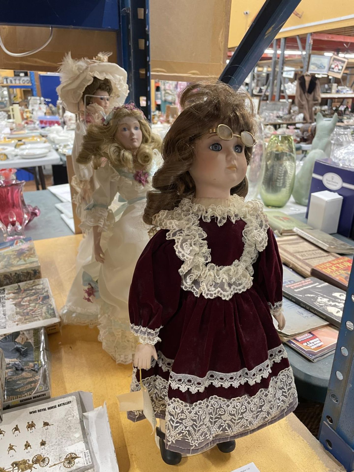 THREE PORCELAIN COLLECTORS DOLLS WITH TRADITIONAL COSTUMES ON STANDS