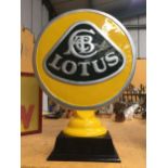 A YELLOW METAL LOTUS SIGN ON WOODEN BASE