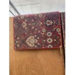 A SMALL RED PATTERNED RUG