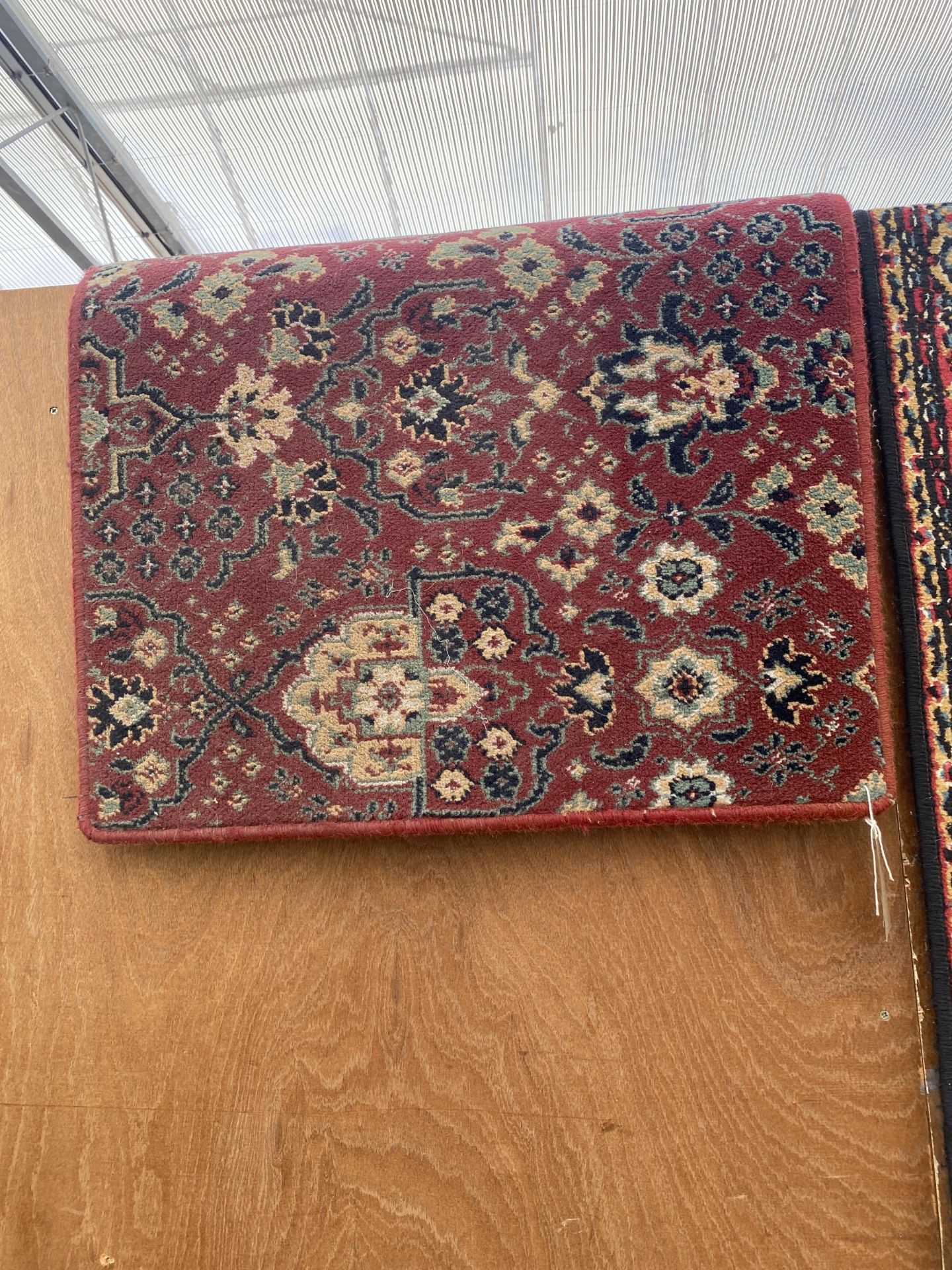 A SMALL RED PATTERNED RUG