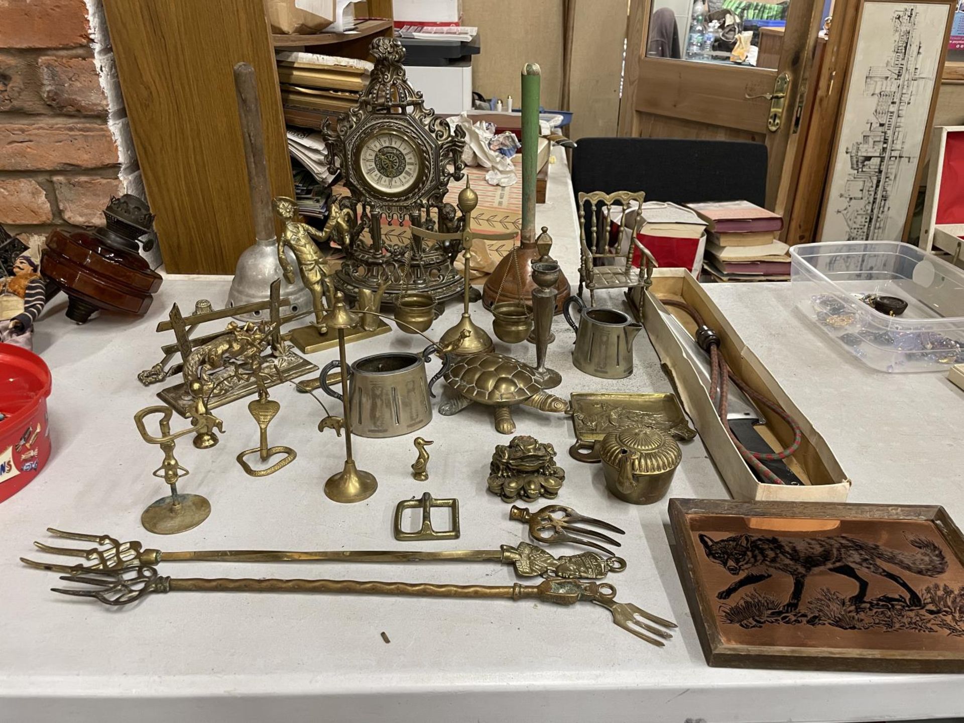 A LARGE QUANTITY OF BRASSWARE TO INCLUDE AN ORNATE MANTLE CLOCK, TOASTING FORKS, ANIMALS, ETC