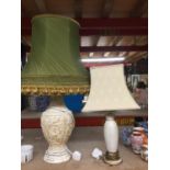 A LARGE VINTAGE WHITE RESIN TABLE LAMP WITH EMBOSSED DETAIL AND A SAGE GREEN SHADE WITH TASSLES