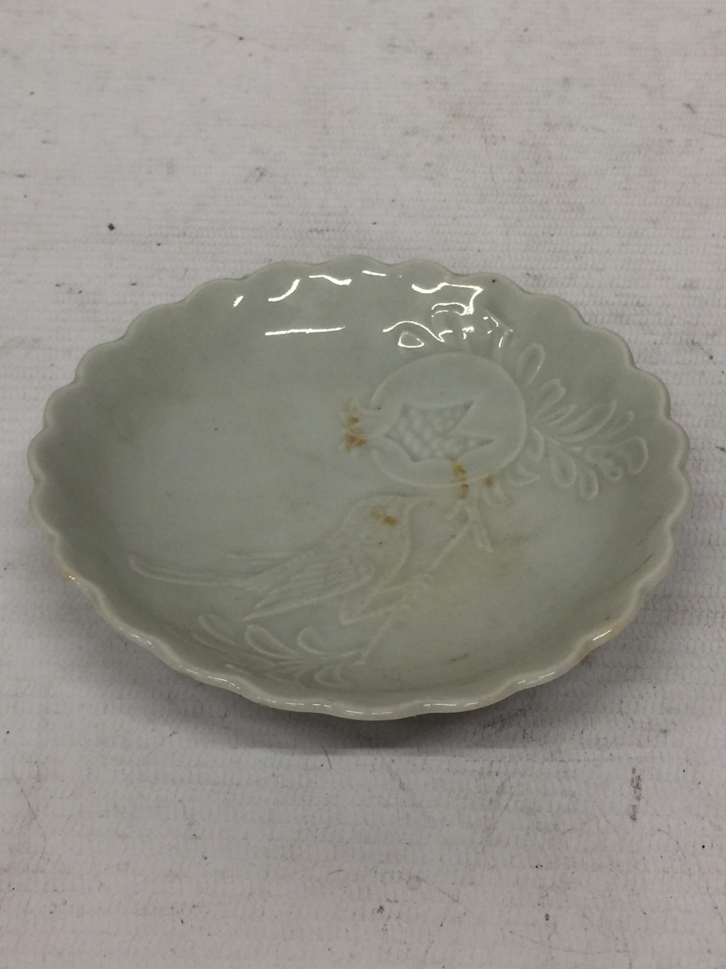 A CHINESE CELADON DISH WITH BIRD & FLORAL DESIGN UNMARKED TO BASE, DIAMETER 11.5CM