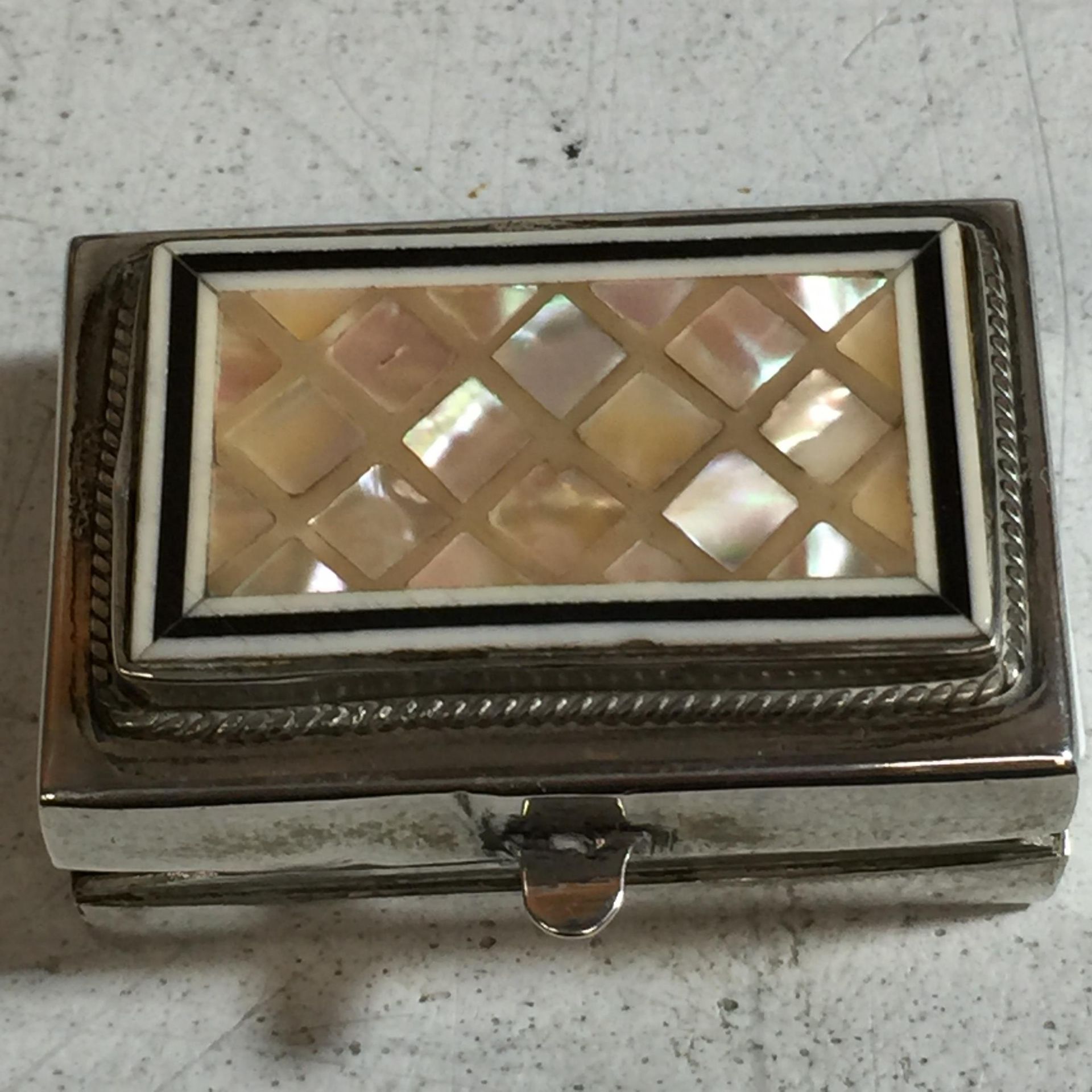 A SILVER TRINKET BOX WITH MOTHER OF PEARL ON THE TOP