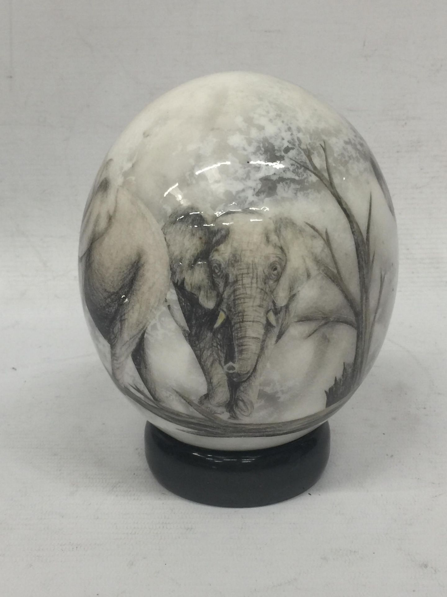 A HANDPAINTED OSTRICH EGG WITH ELEPHANT DESIGN ON STAND